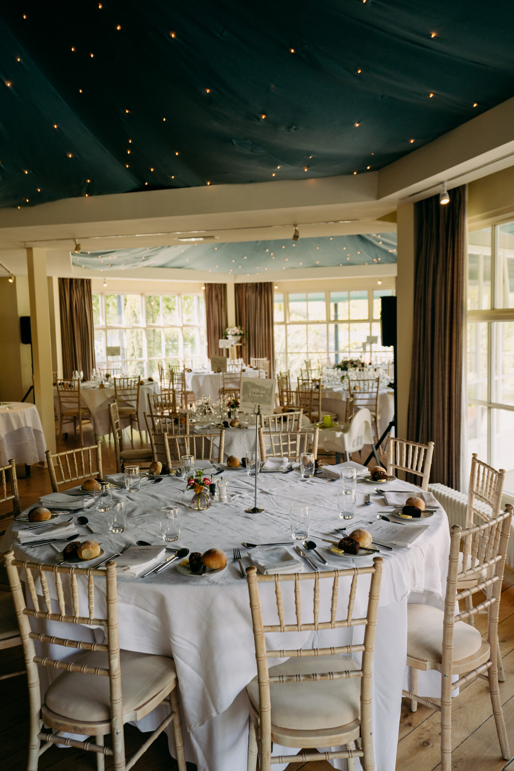 A large dining room with white tables and chairs