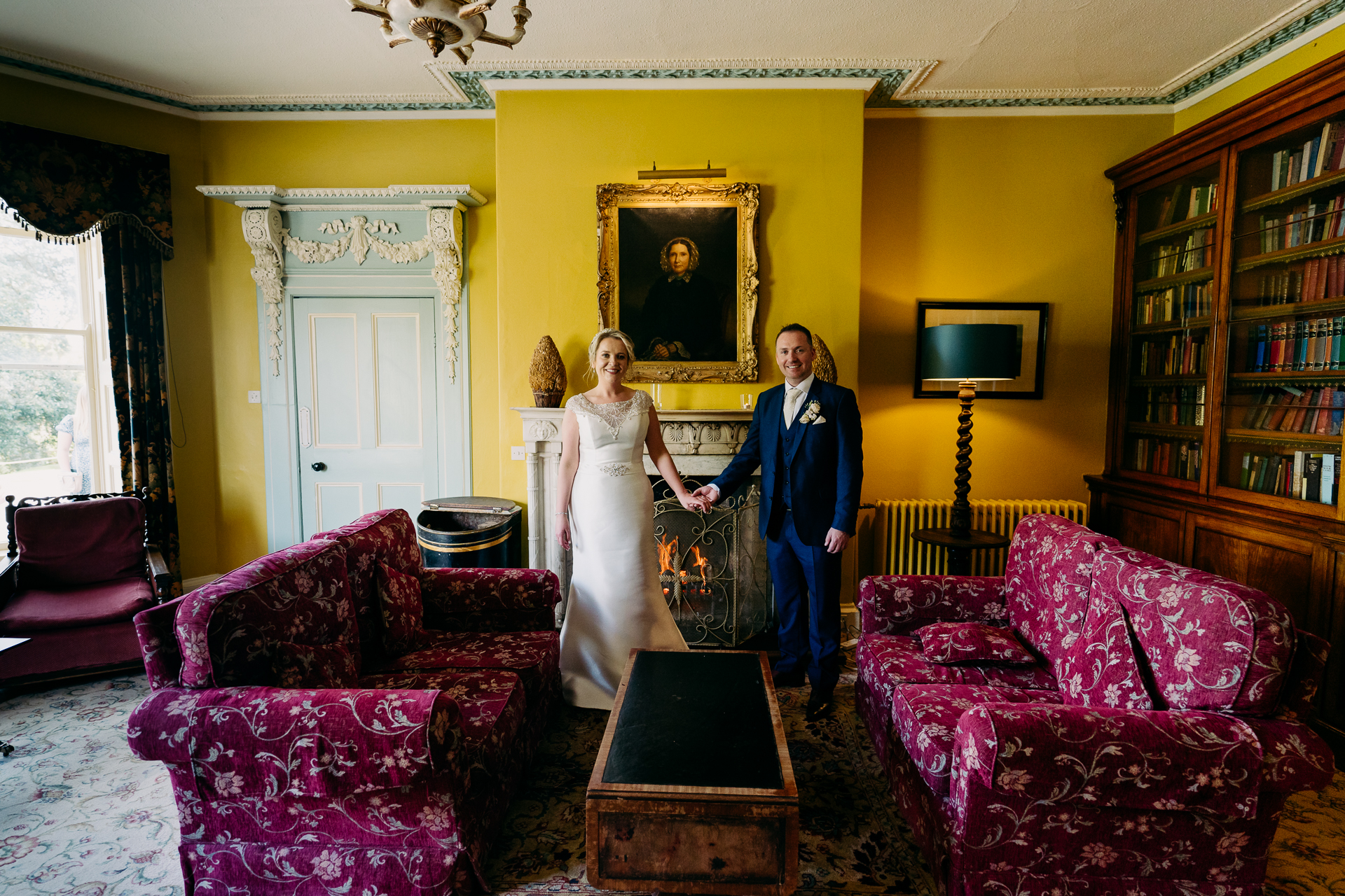 A bride and a groom in a room with a bookcase and a bookcase