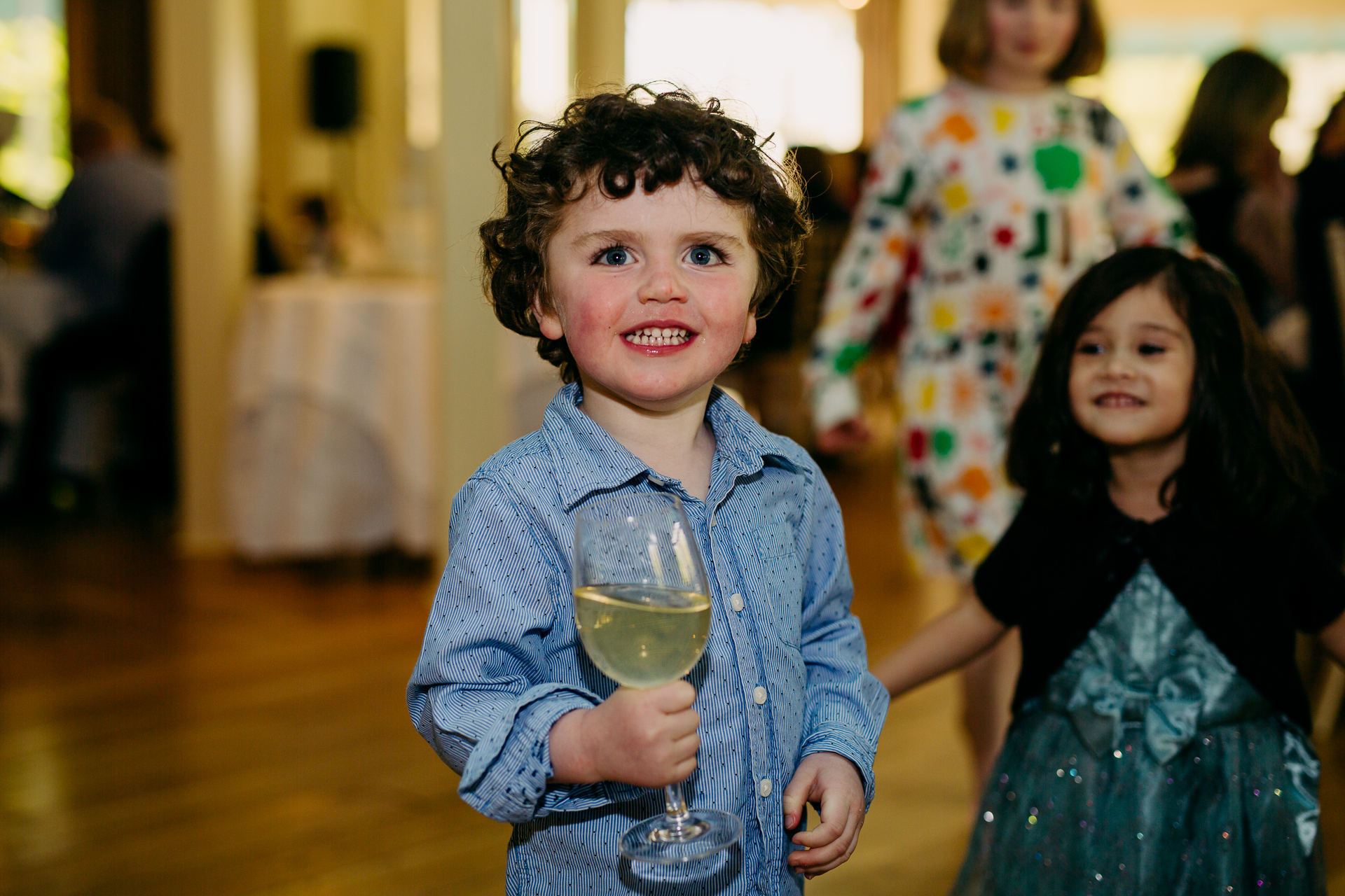 A young girl holding a glass of wine