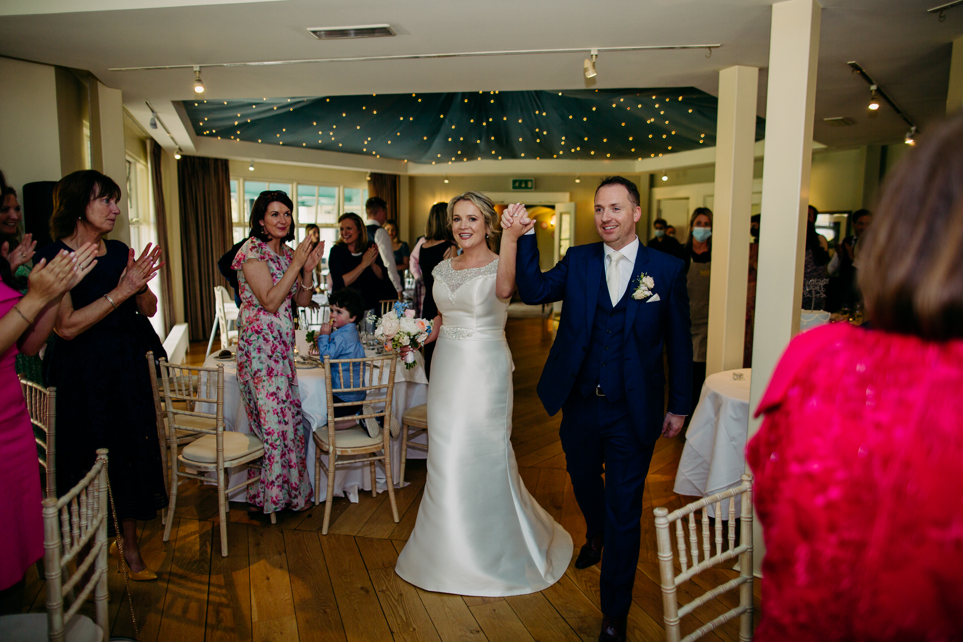 A man and woman walking down a hall with a group of people