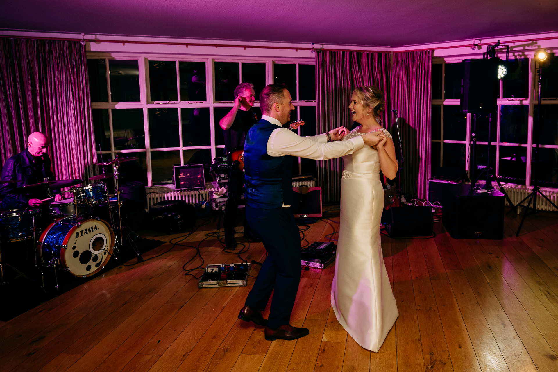 A man and woman dancing on a stage with a band playing