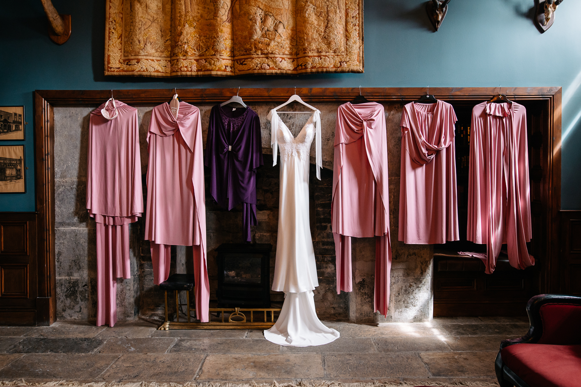 A room with a row of dresses on the wall