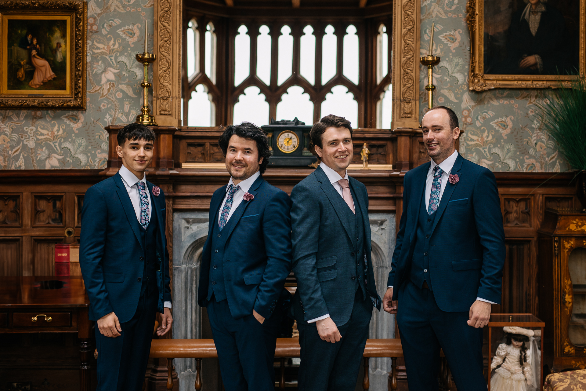 A group of men in suits standing in front of a wall with paintings