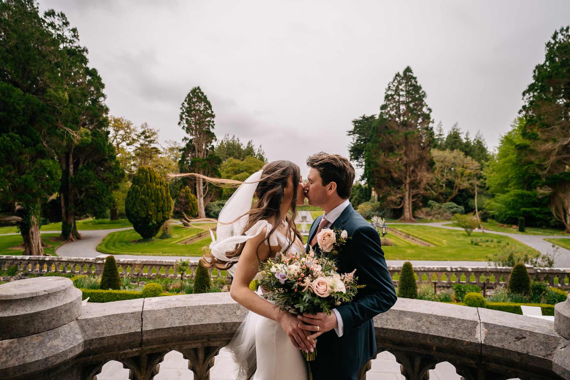 A man and woman kissing on a bridge