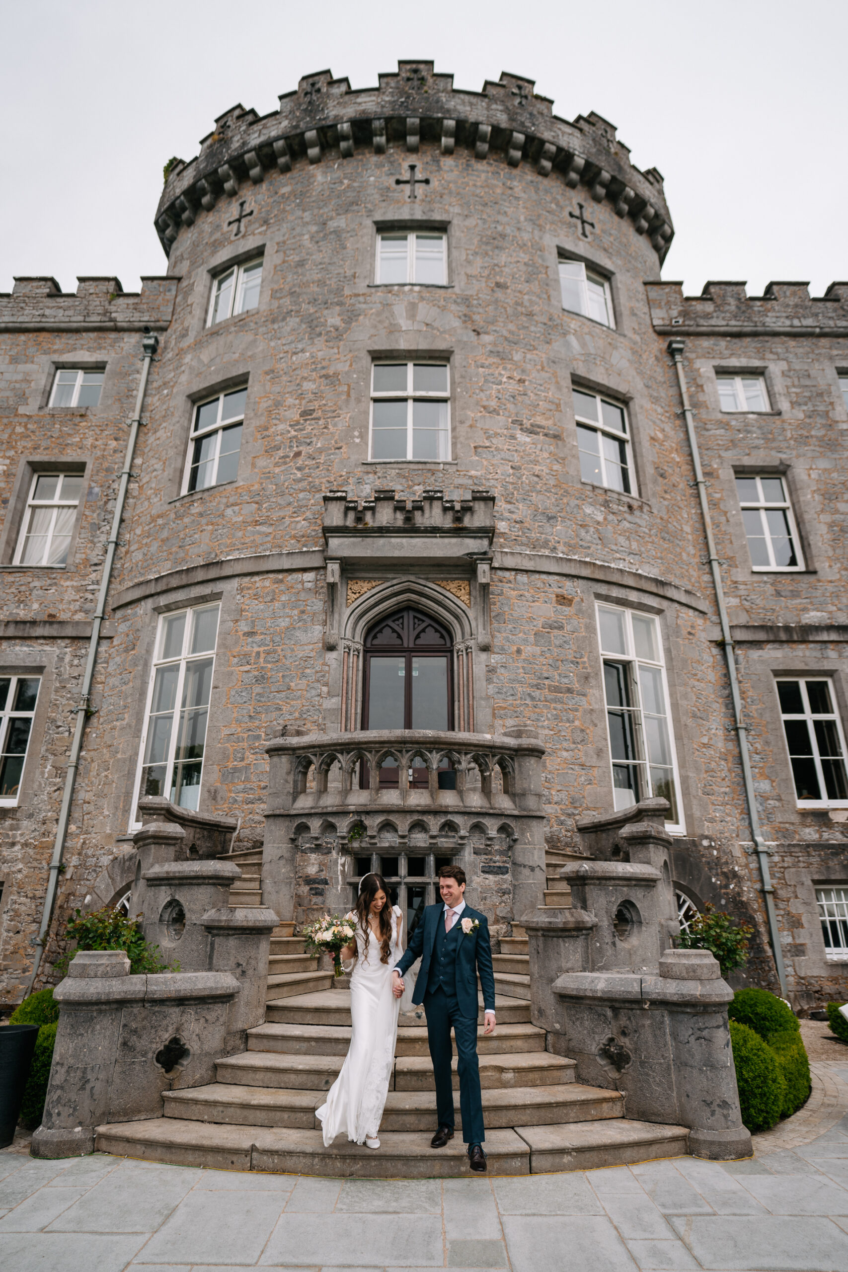 A man and woman posing for a picture in front of a large building