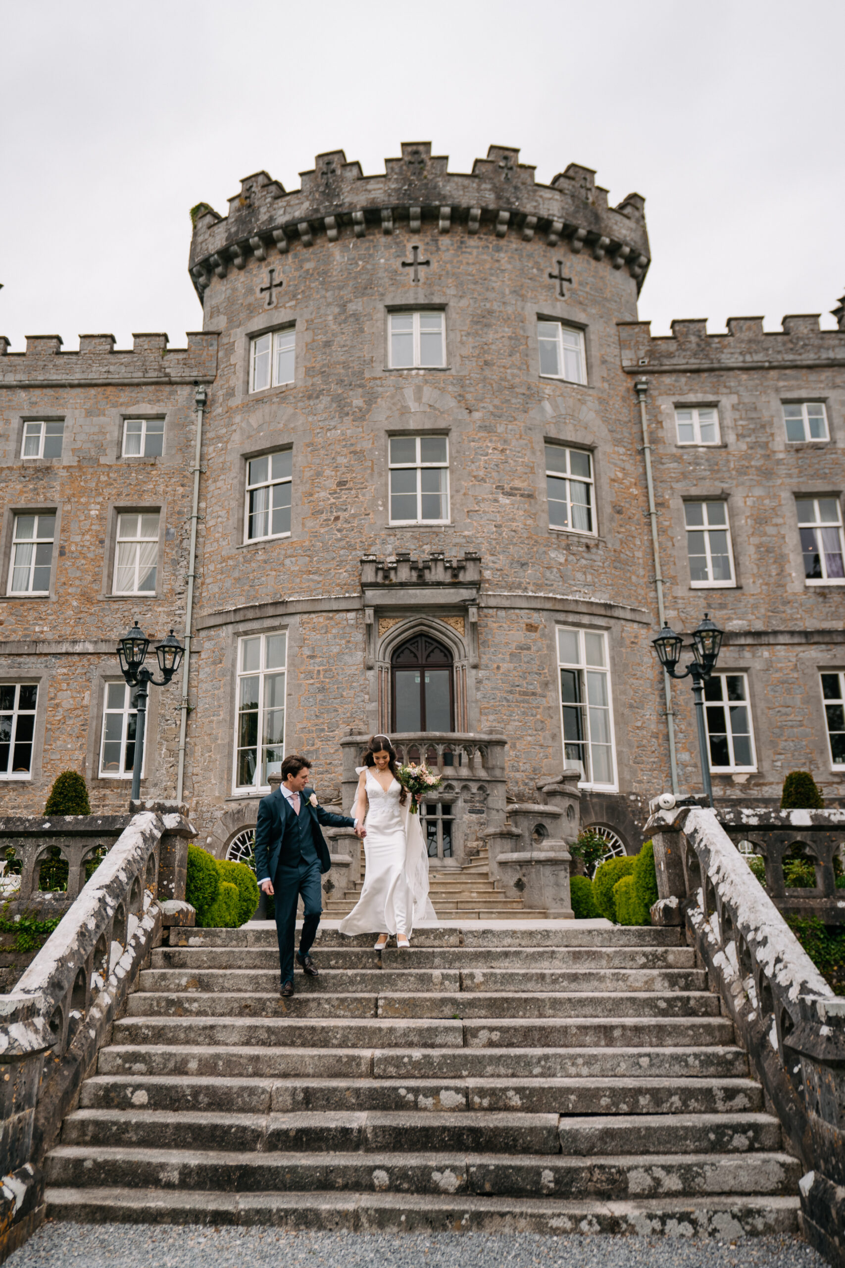 A bride and groom walking up stairs