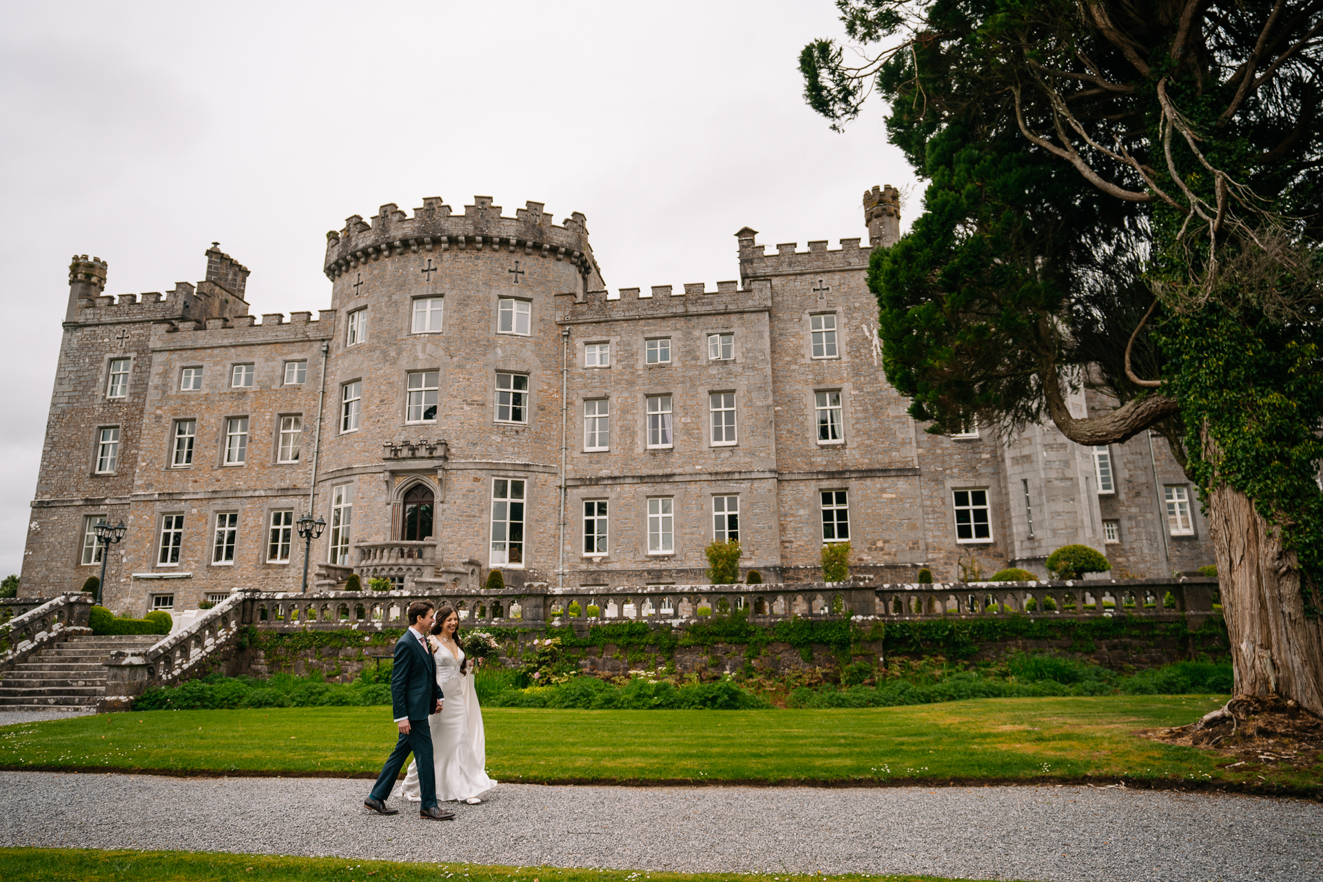 A man and woman walking in front of a large building