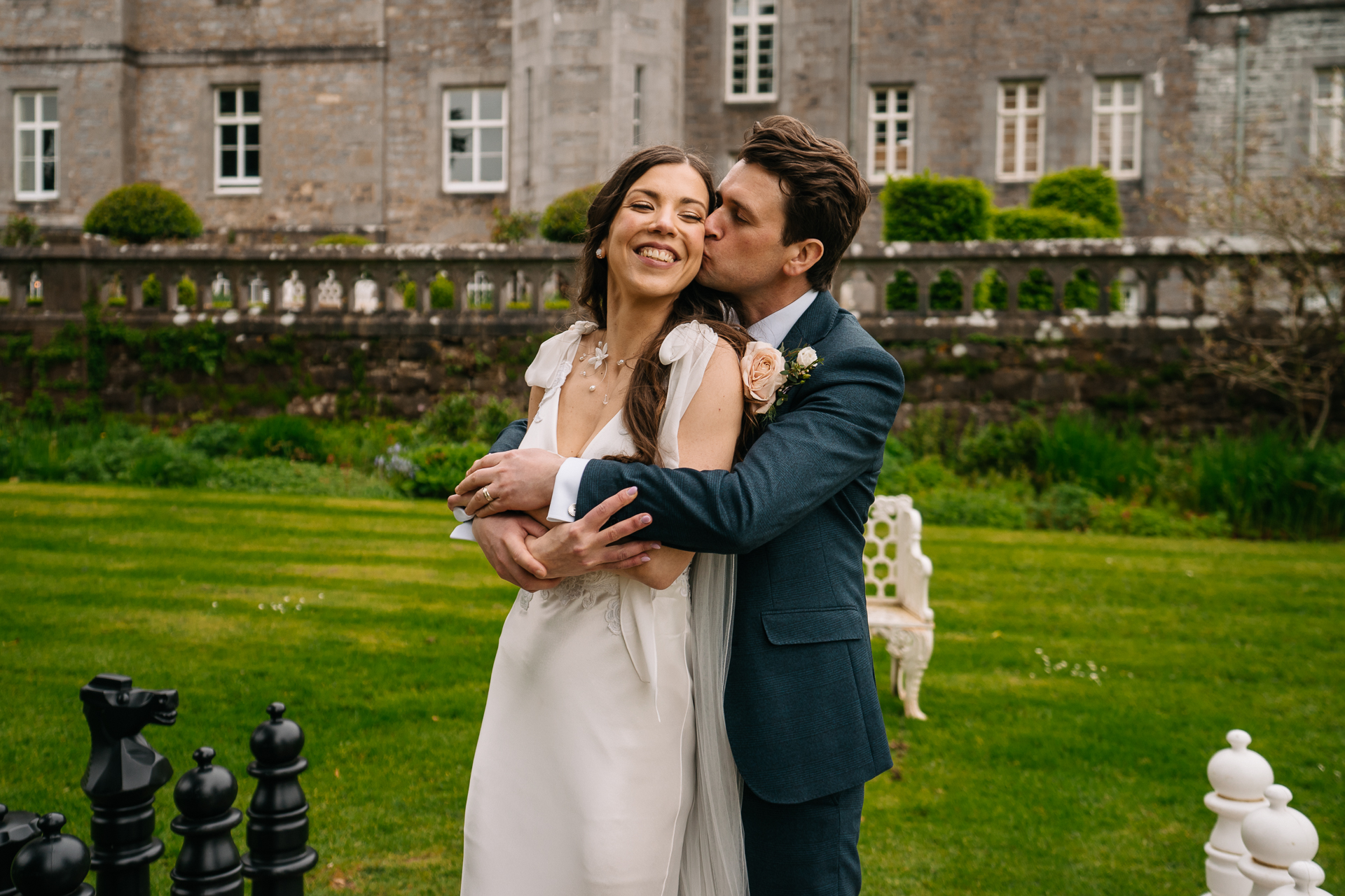 A man and woman hugging in front of a building