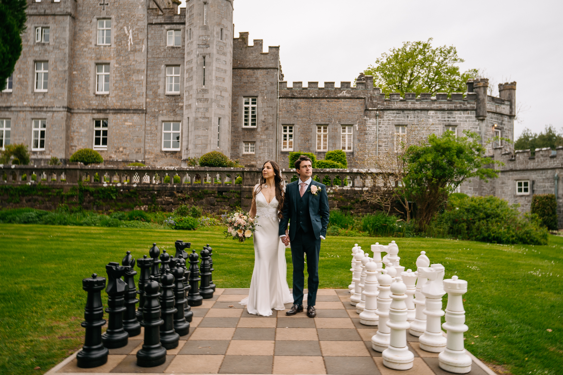 A man and woman posing in front of a castle