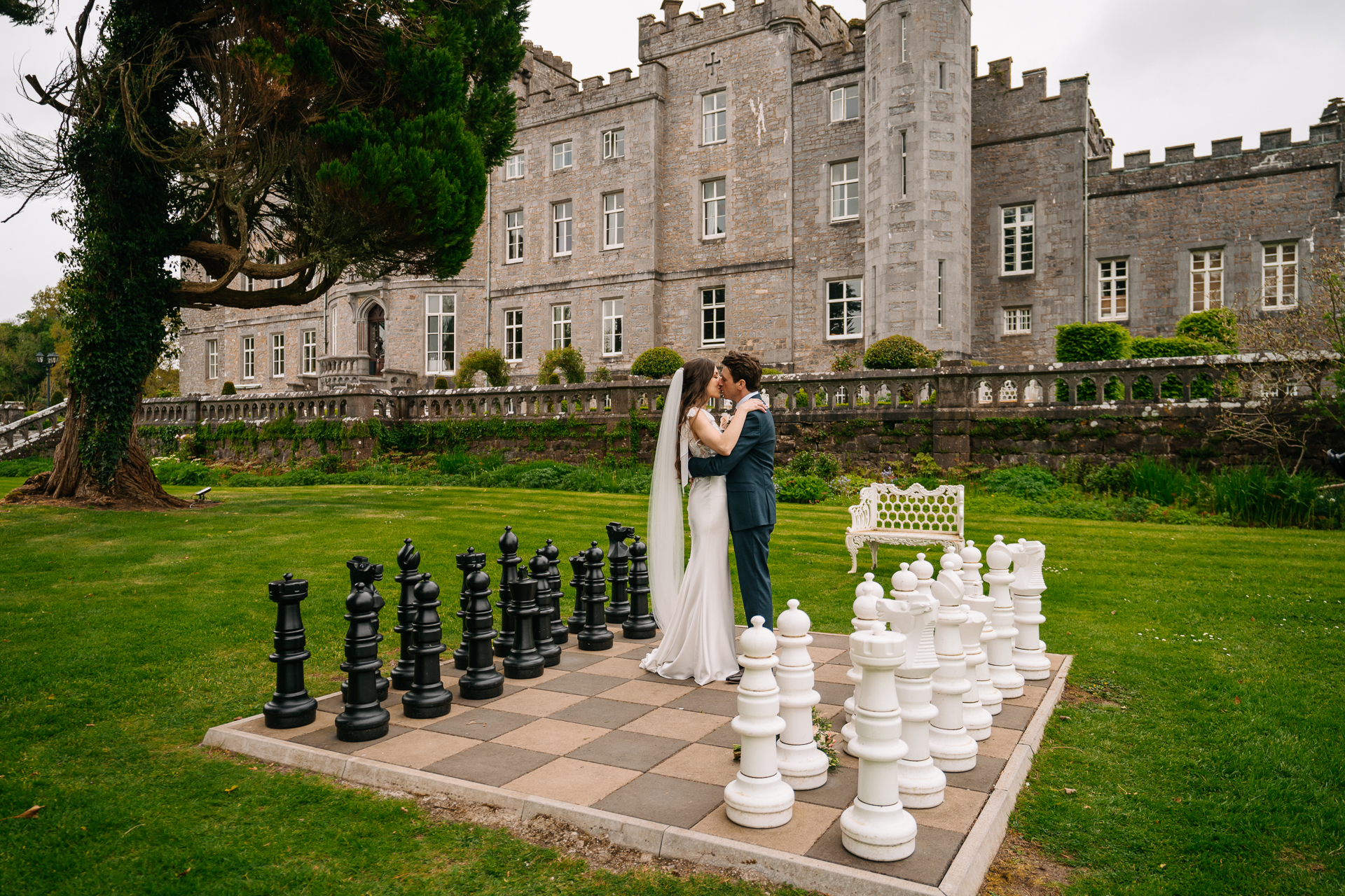 A man and woman kissing in front of a large building