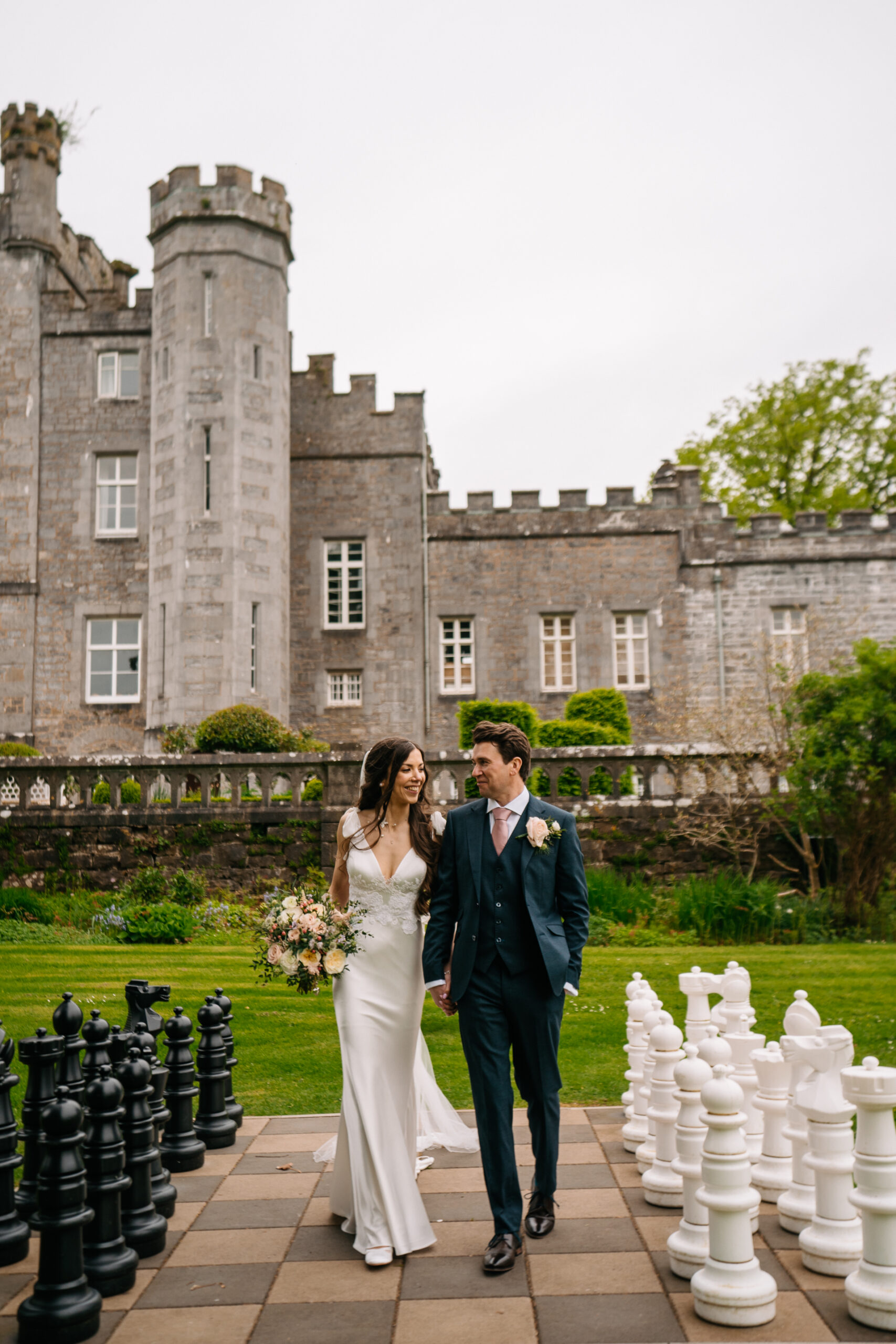 A man and woman posing in front of a castle