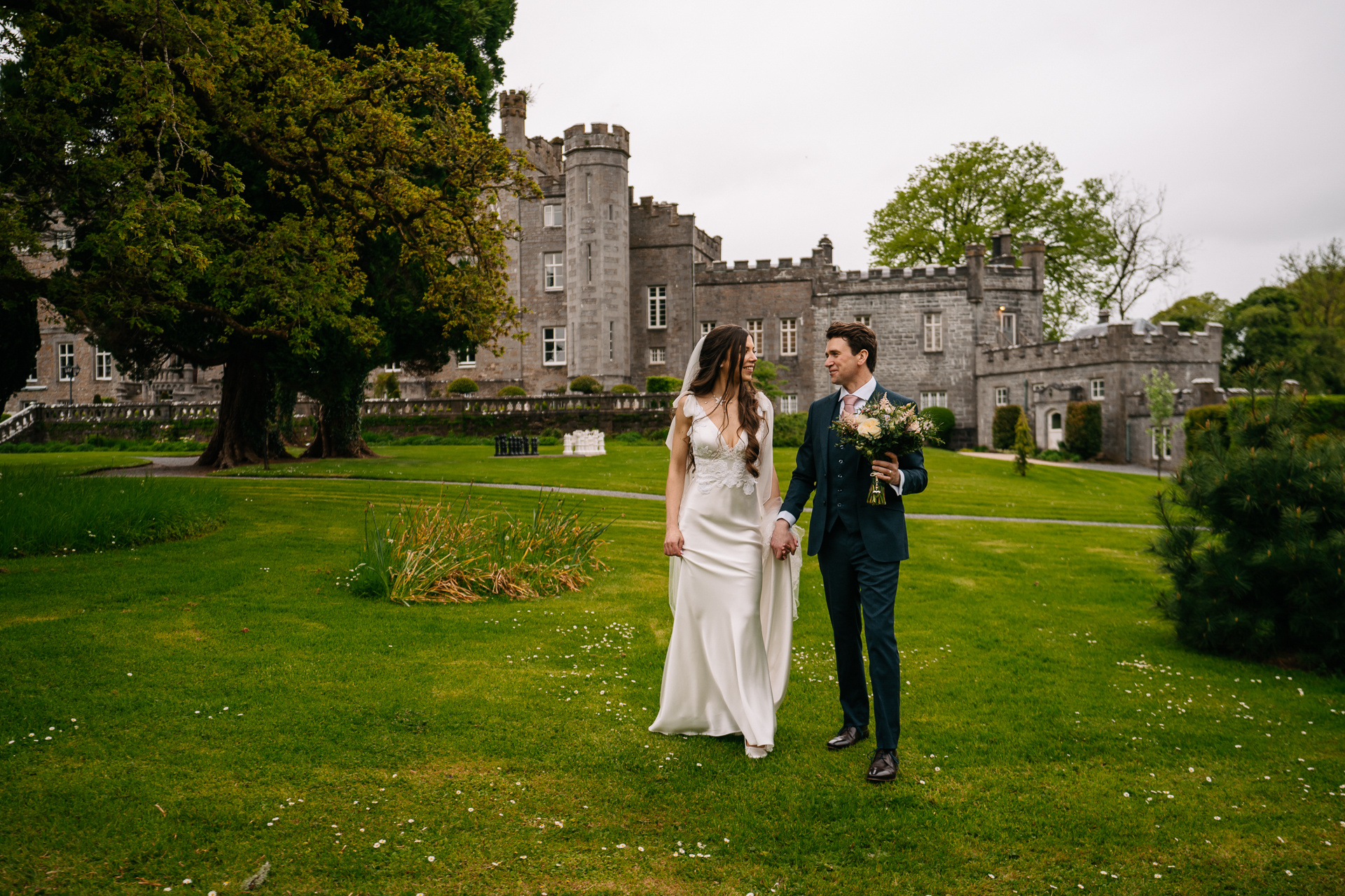 A man and woman posing for a picture in front of a castle