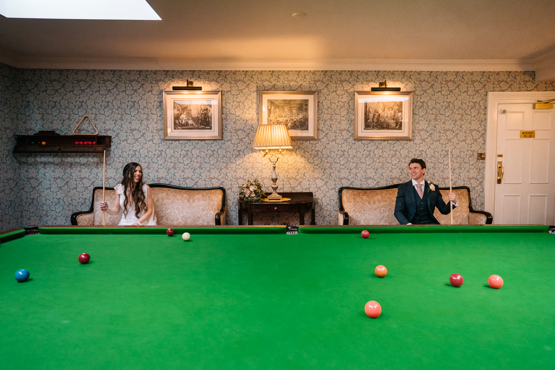 Bride and groom posing elegantly by the billiard table in Markree Castle's game room.