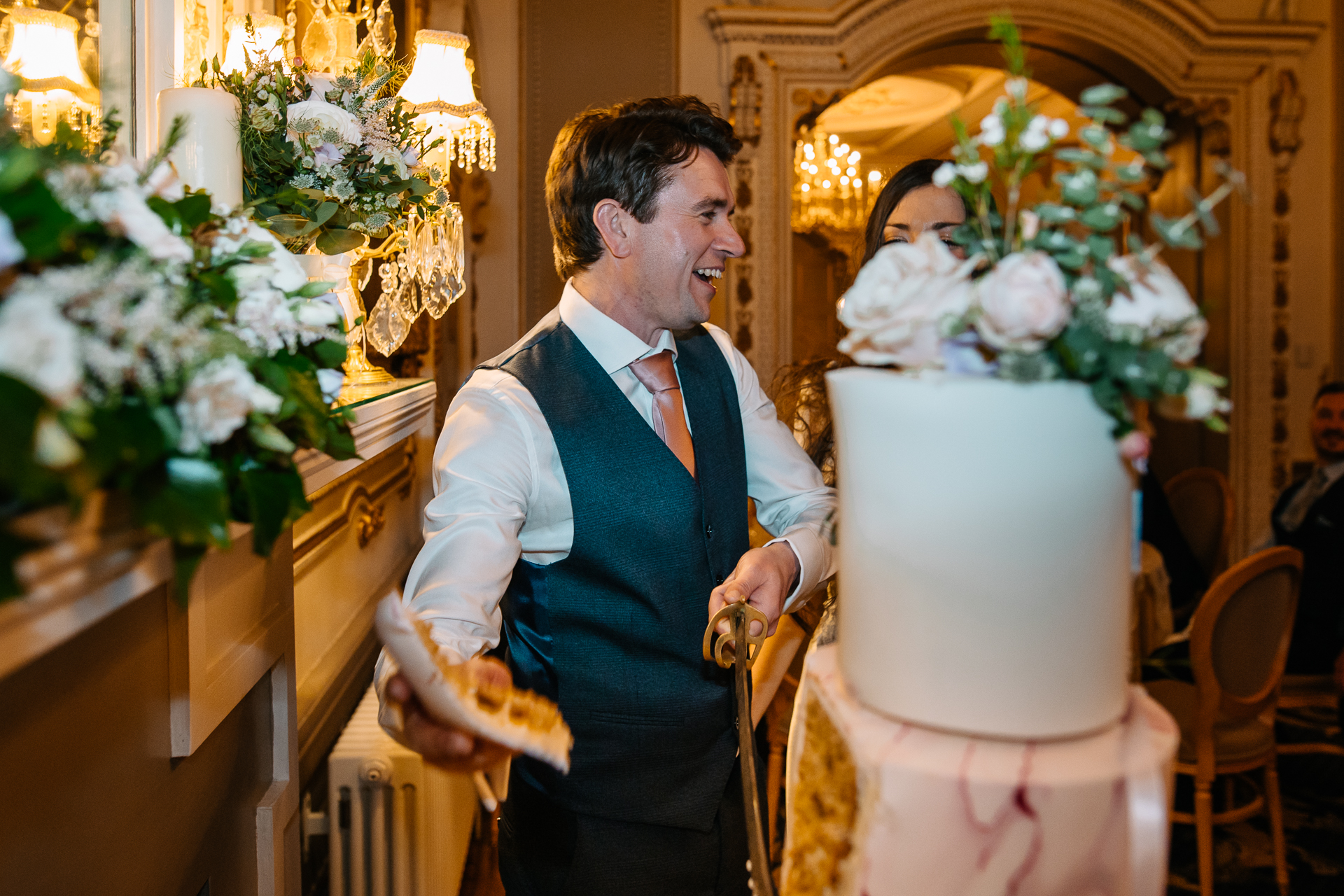 A man in a suit holding a cake