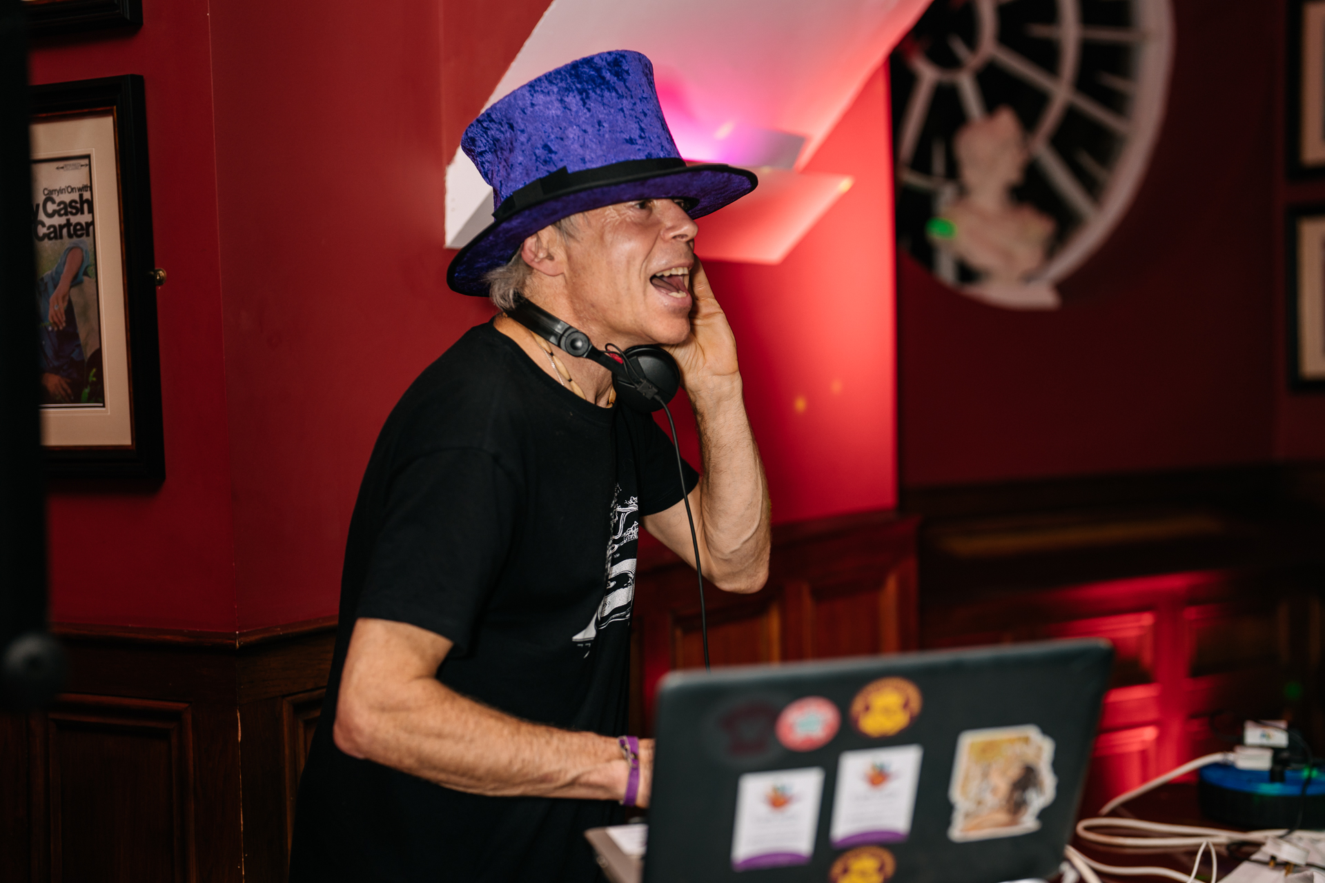 A man wearing a hat and headphones and holding a laptop