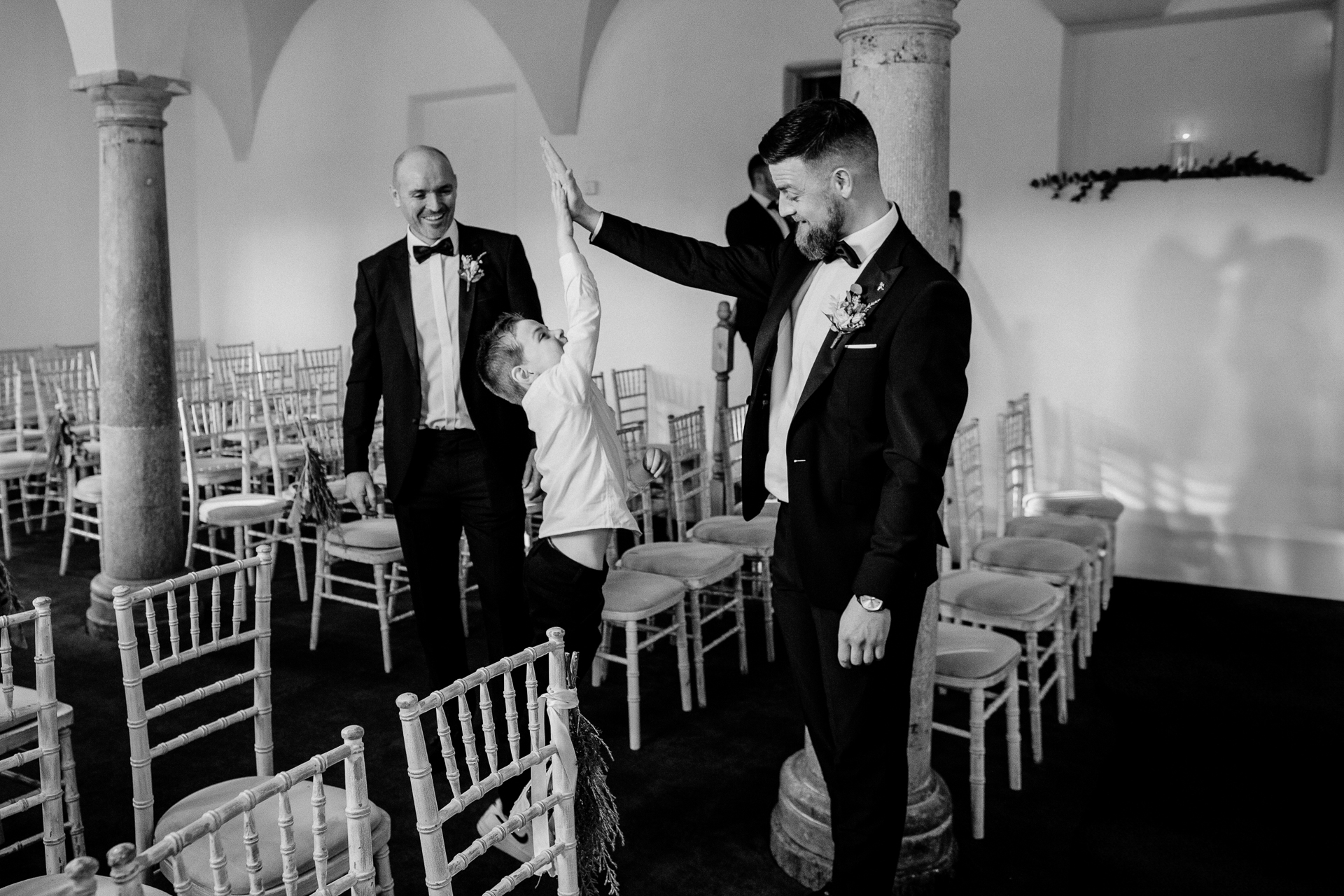 A man in a tuxedo pointing at another man in a suit