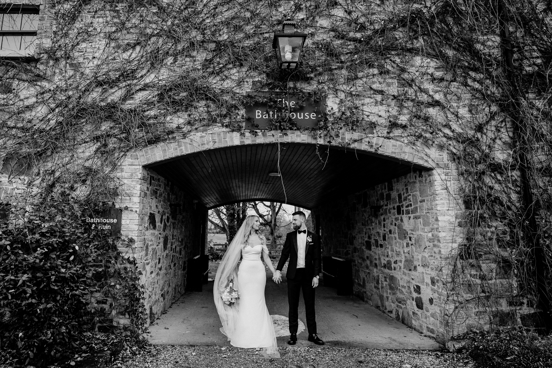 A bride and groom kissing in a tunnel