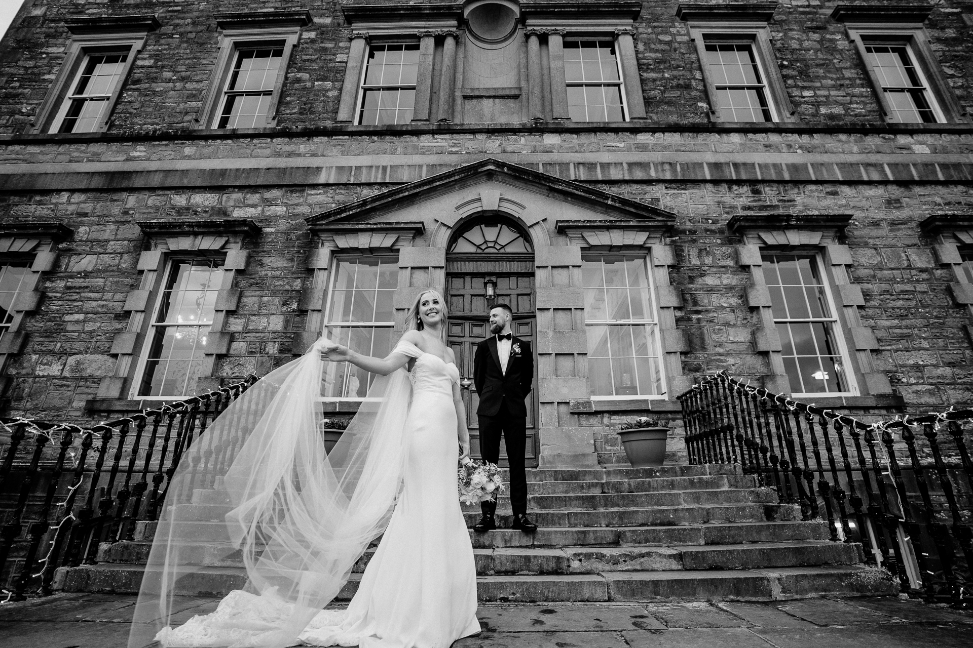 A bride and groom posing on stairs