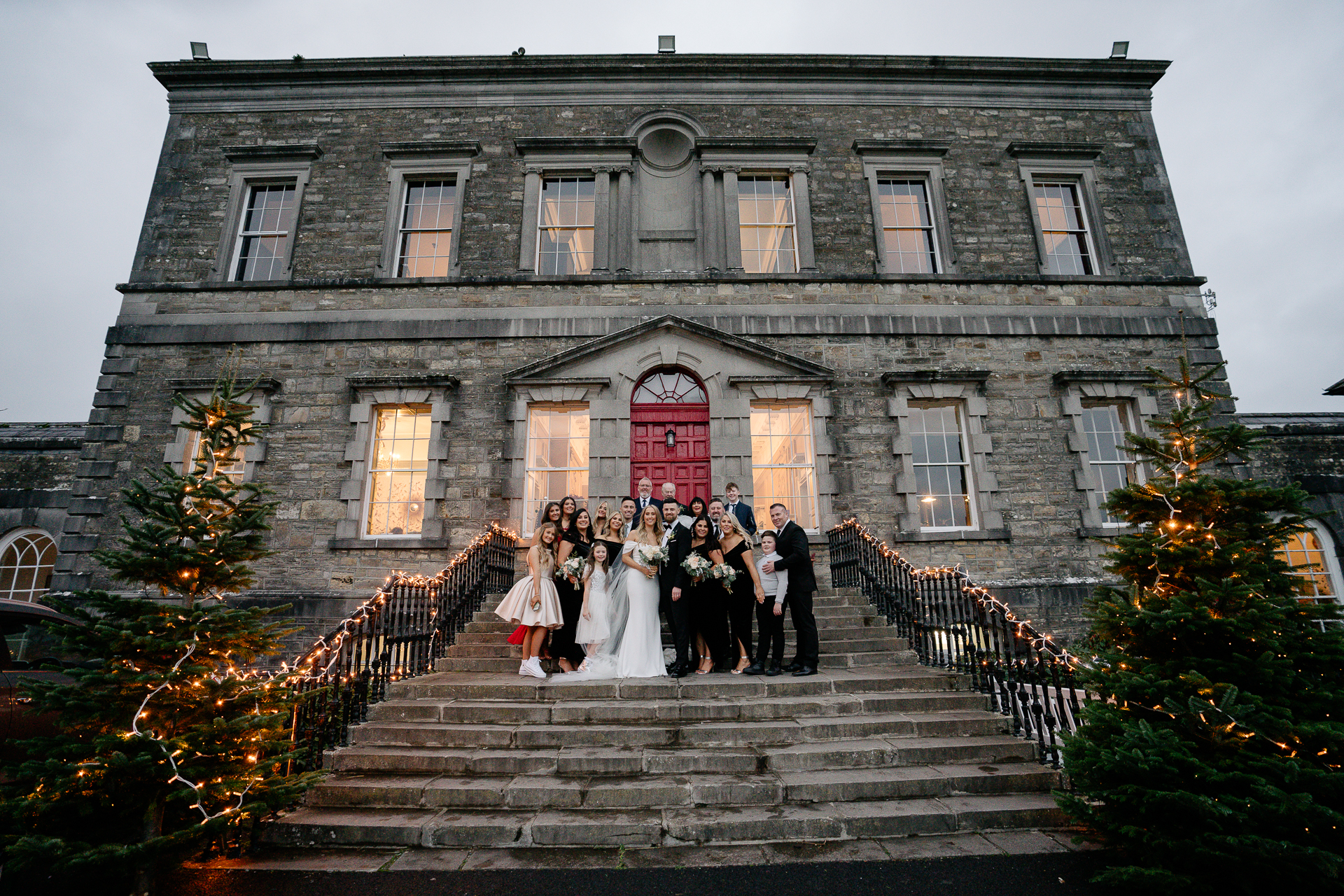 A group of people posing for a photo on stairs in front of a building