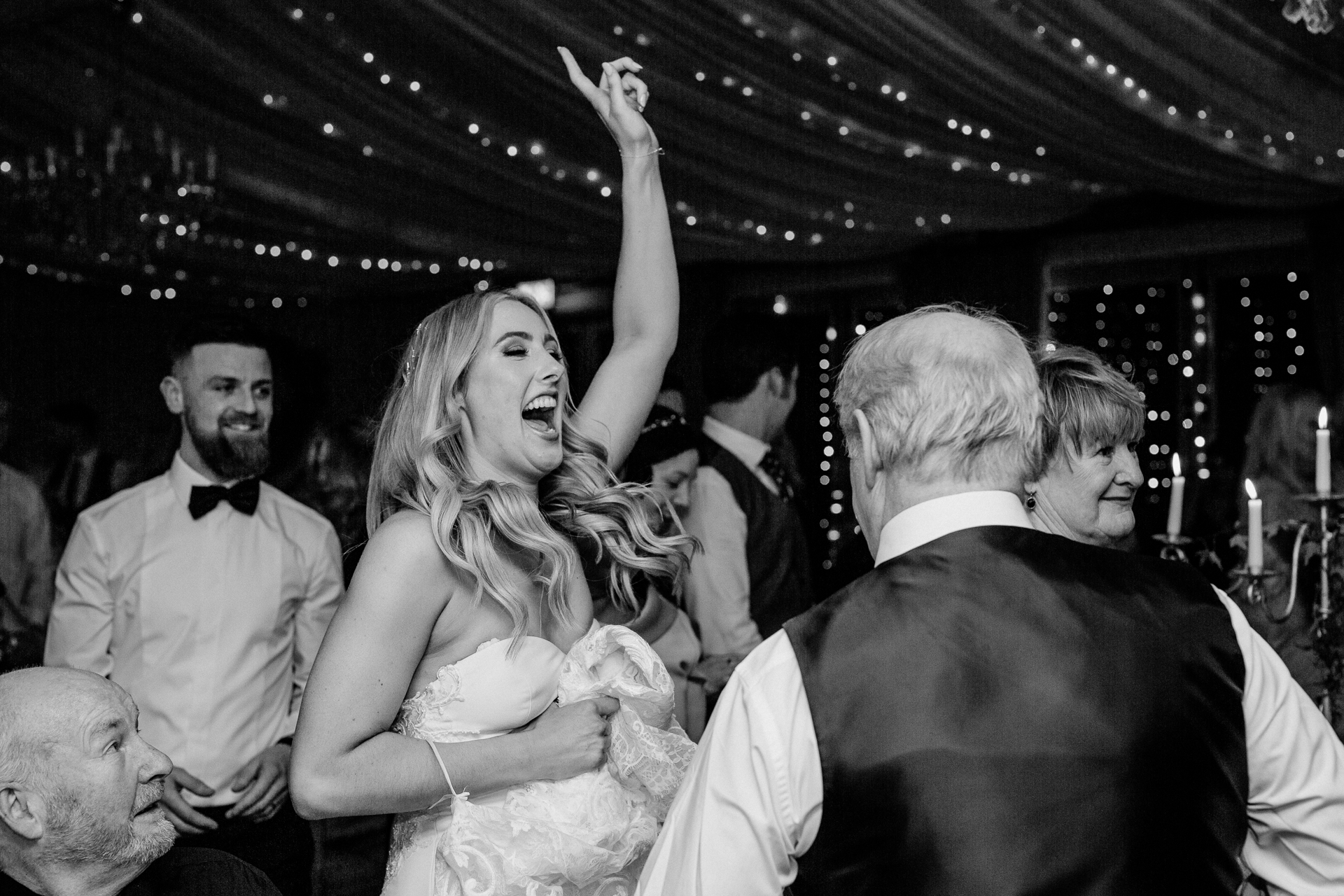 A woman in a white dress dancing with a man in a tuxedo