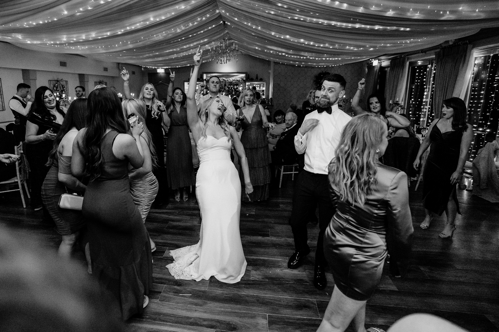 A man and woman dancing in a room full of people