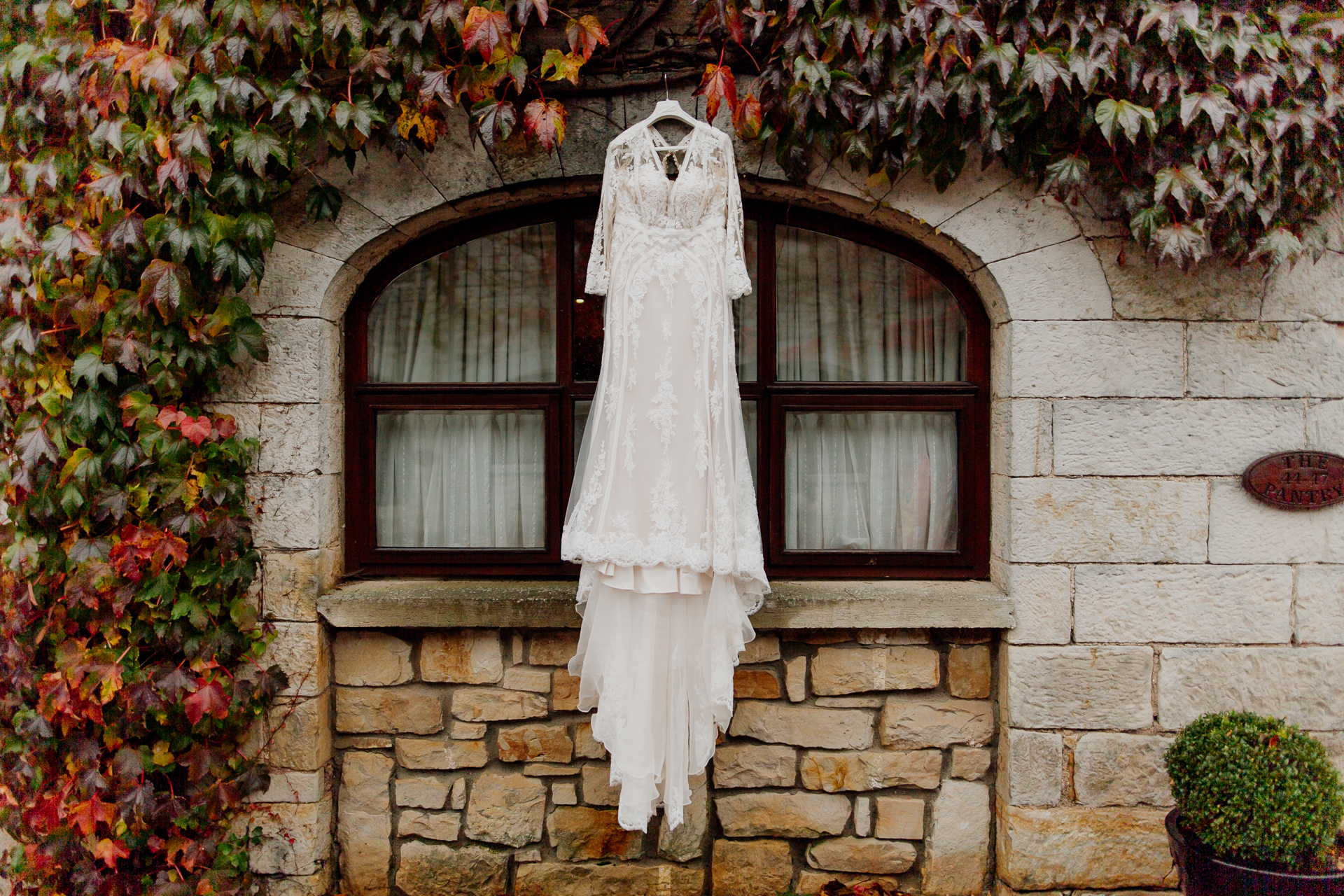 A statue of a person in a white dress in front of a brick building