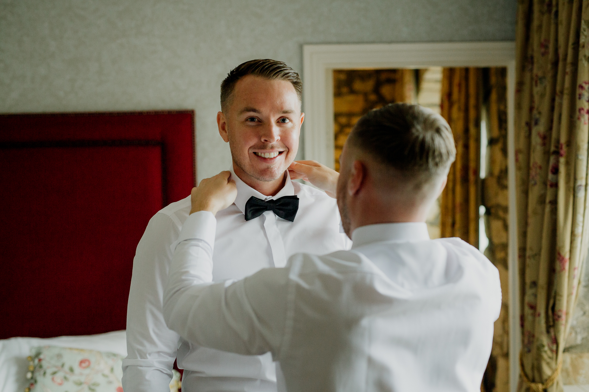 A man in a tuxedo hugging another man in a tuxedo