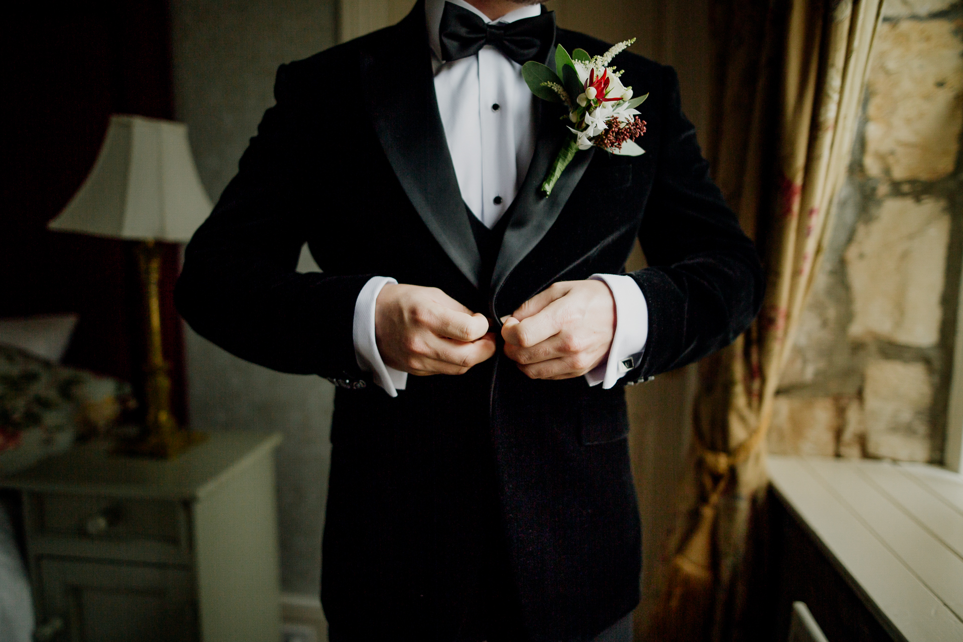 A person in a tuxedo holding the hands together