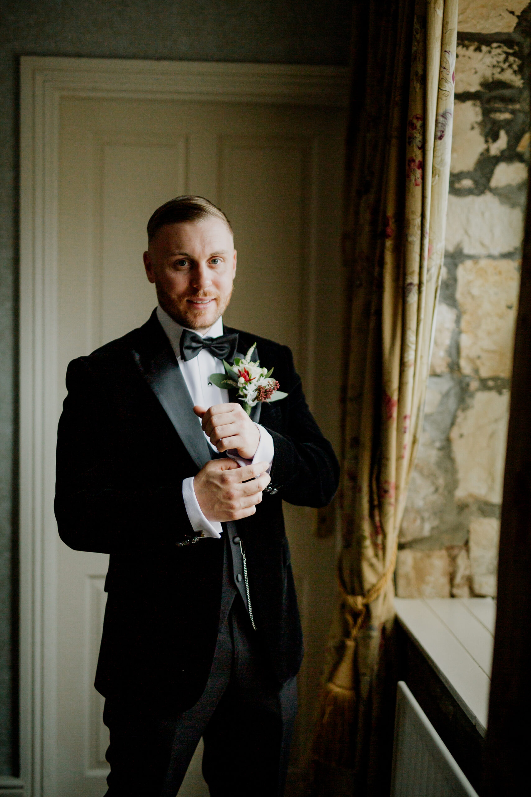 A man in a tuxedo holding a bouquet of flowers