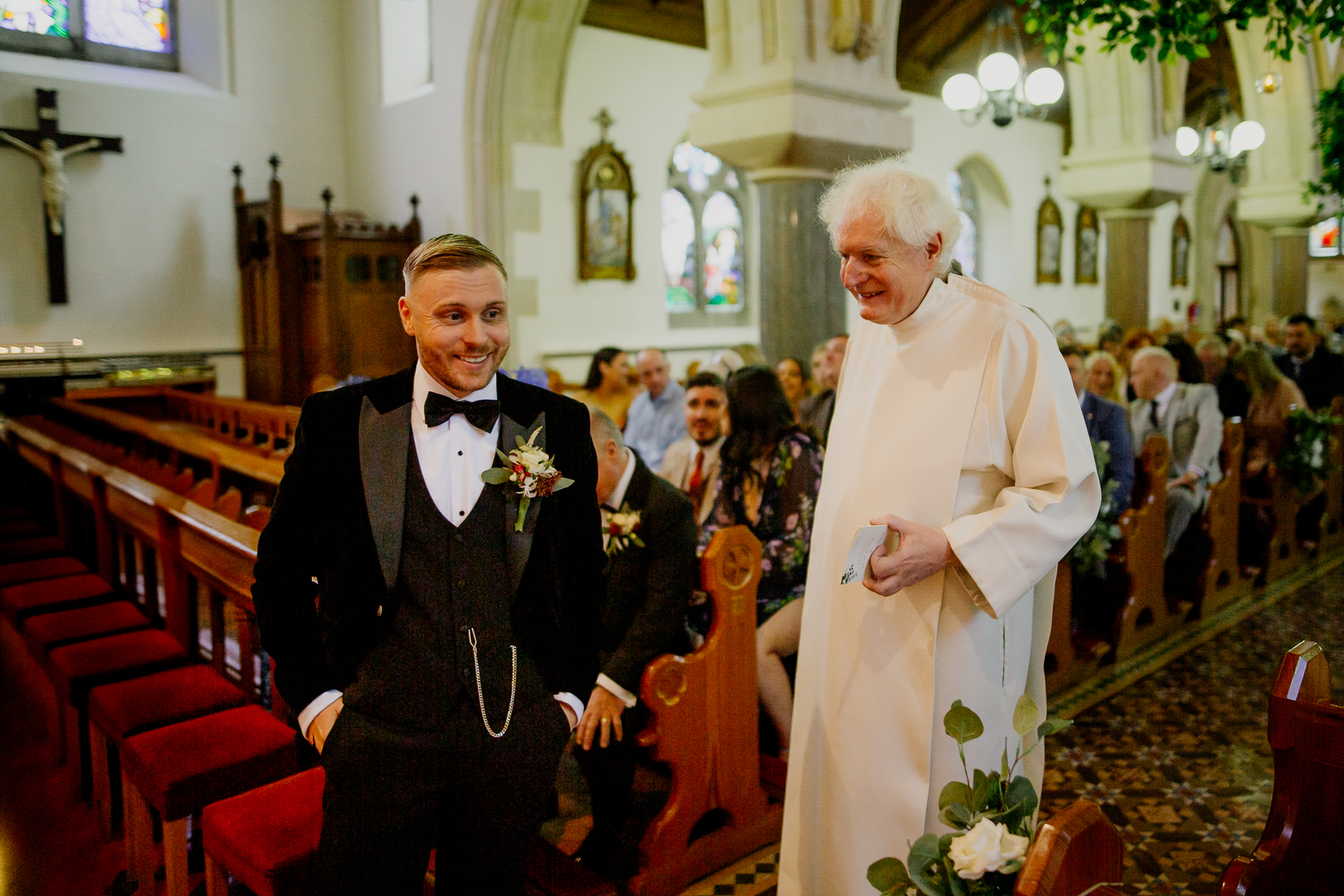 A man in a tuxedo standing next to a man in a suit and tie