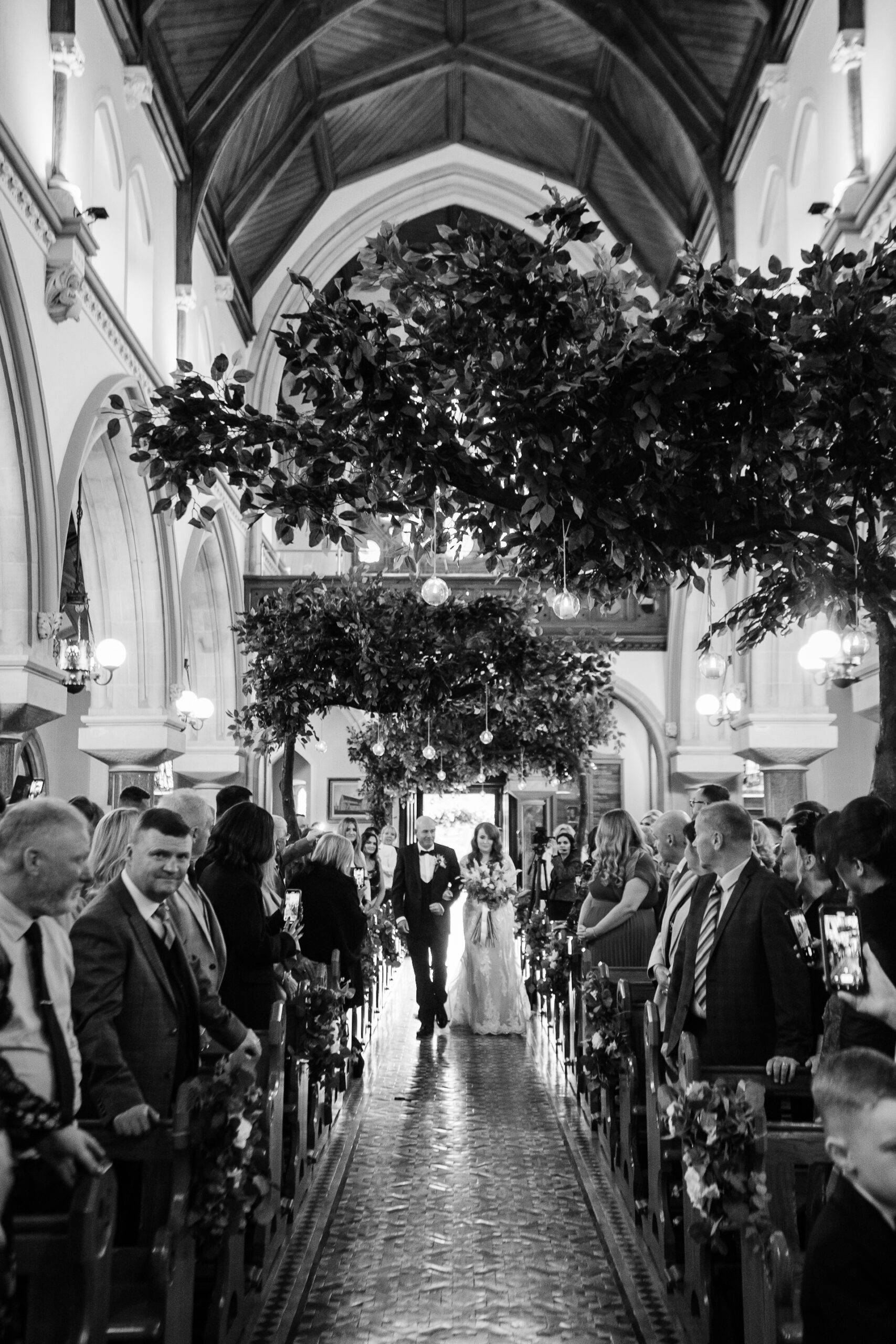 A group of people walking down a street lined with trees