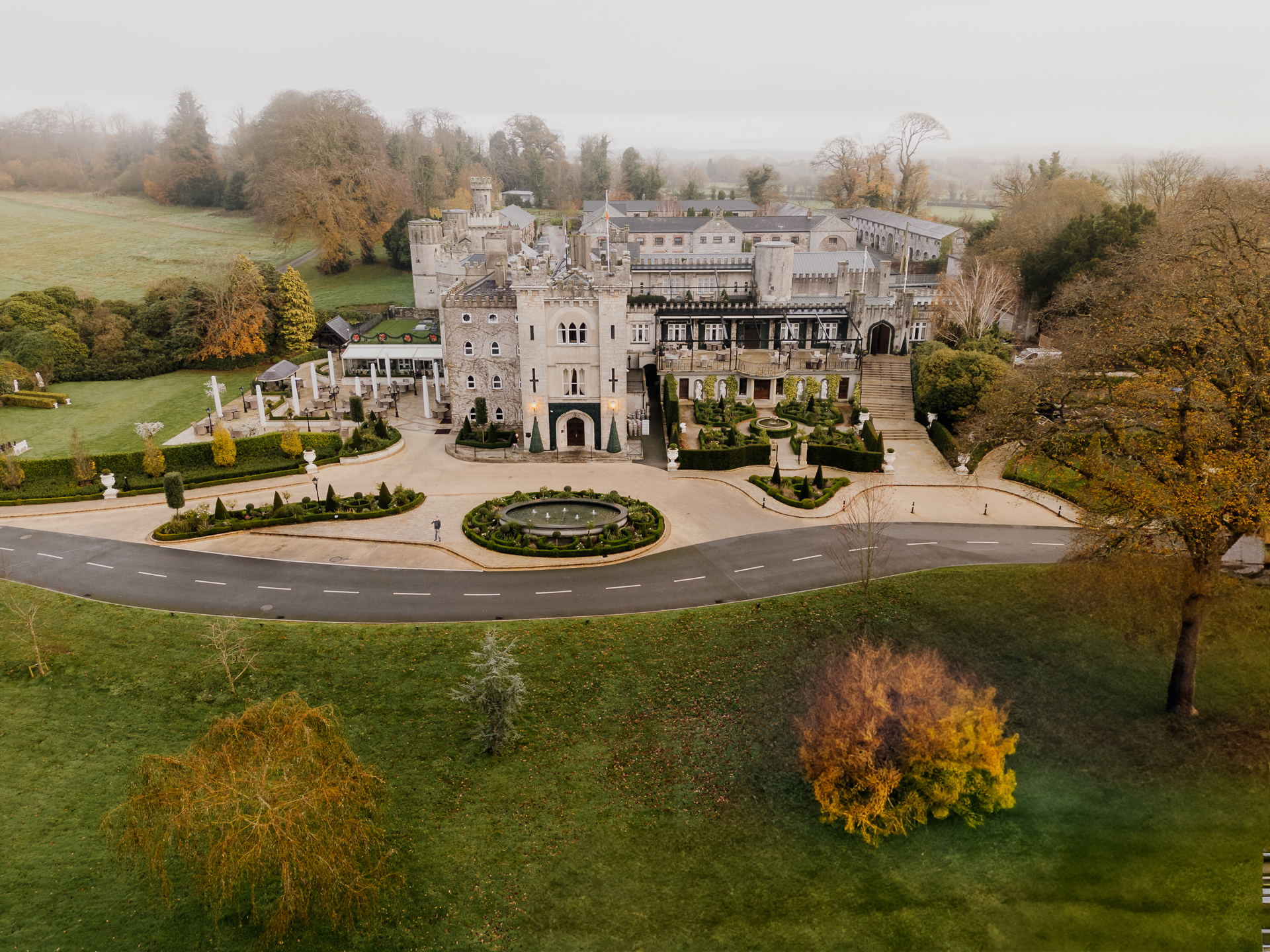 A large white house with a lawn and trees in front of it