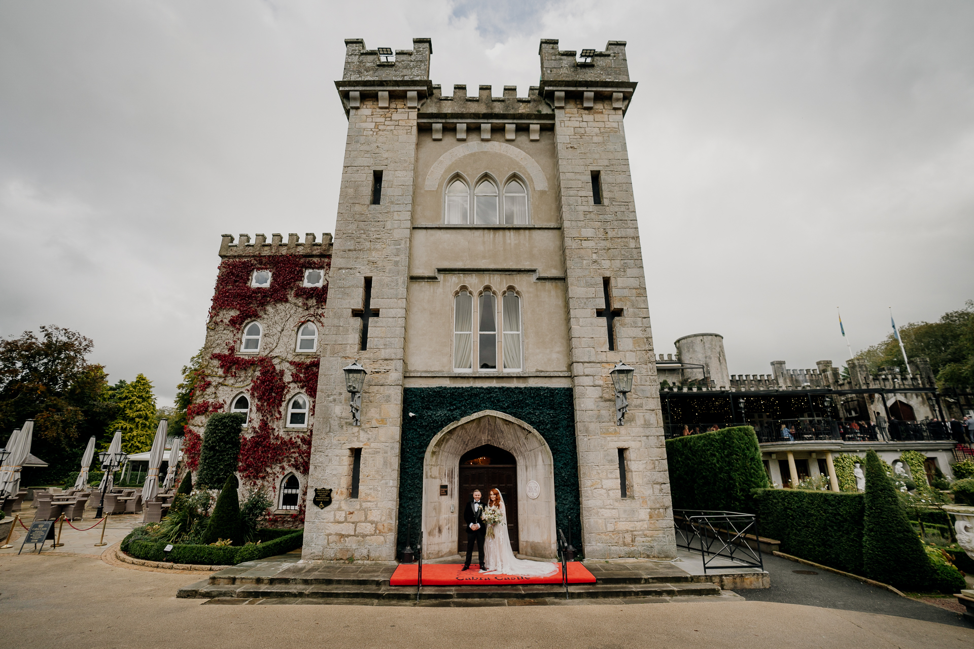 A couple people standing in front of a large stone building