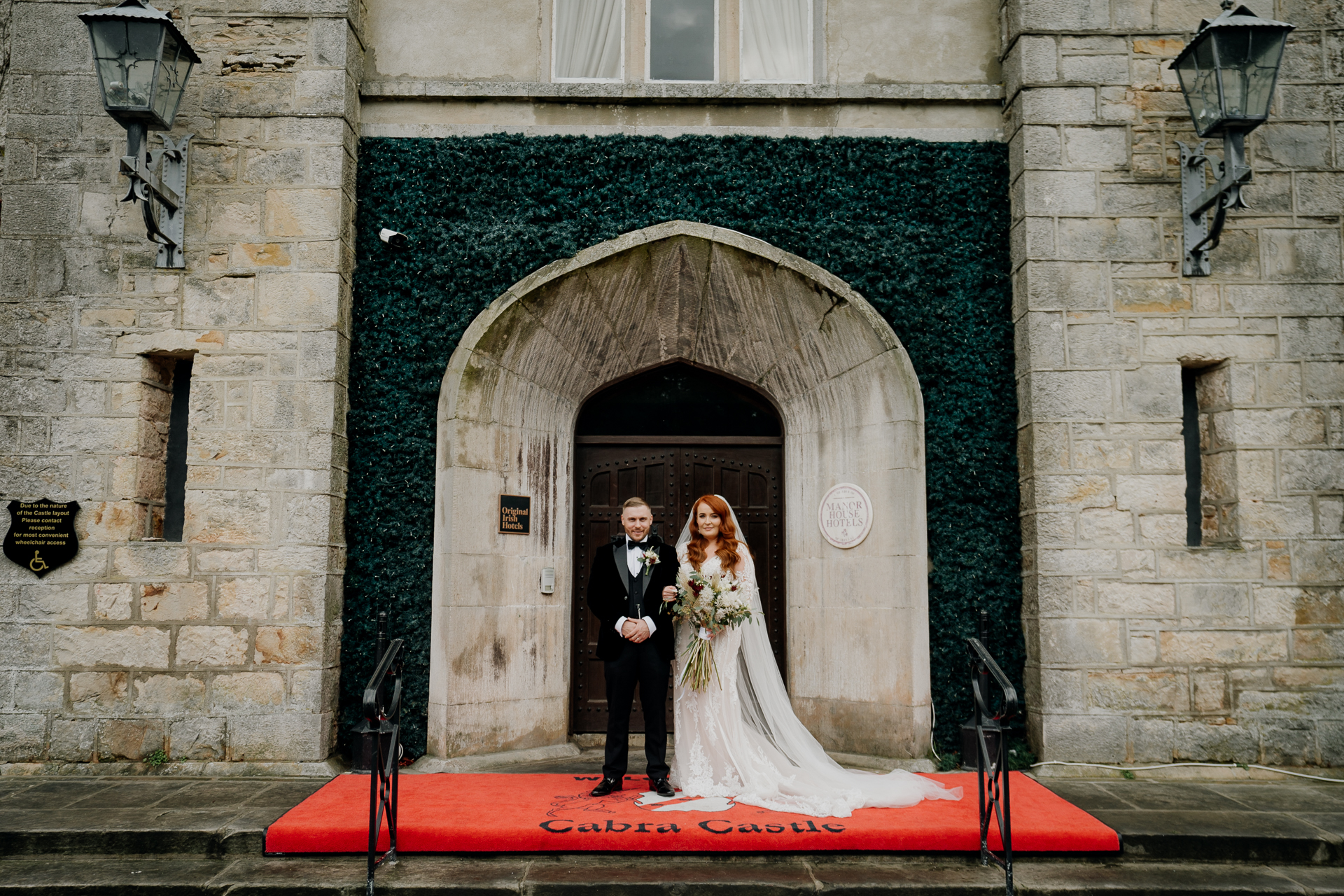 A man and woman in wedding attire standing in front of a doorway