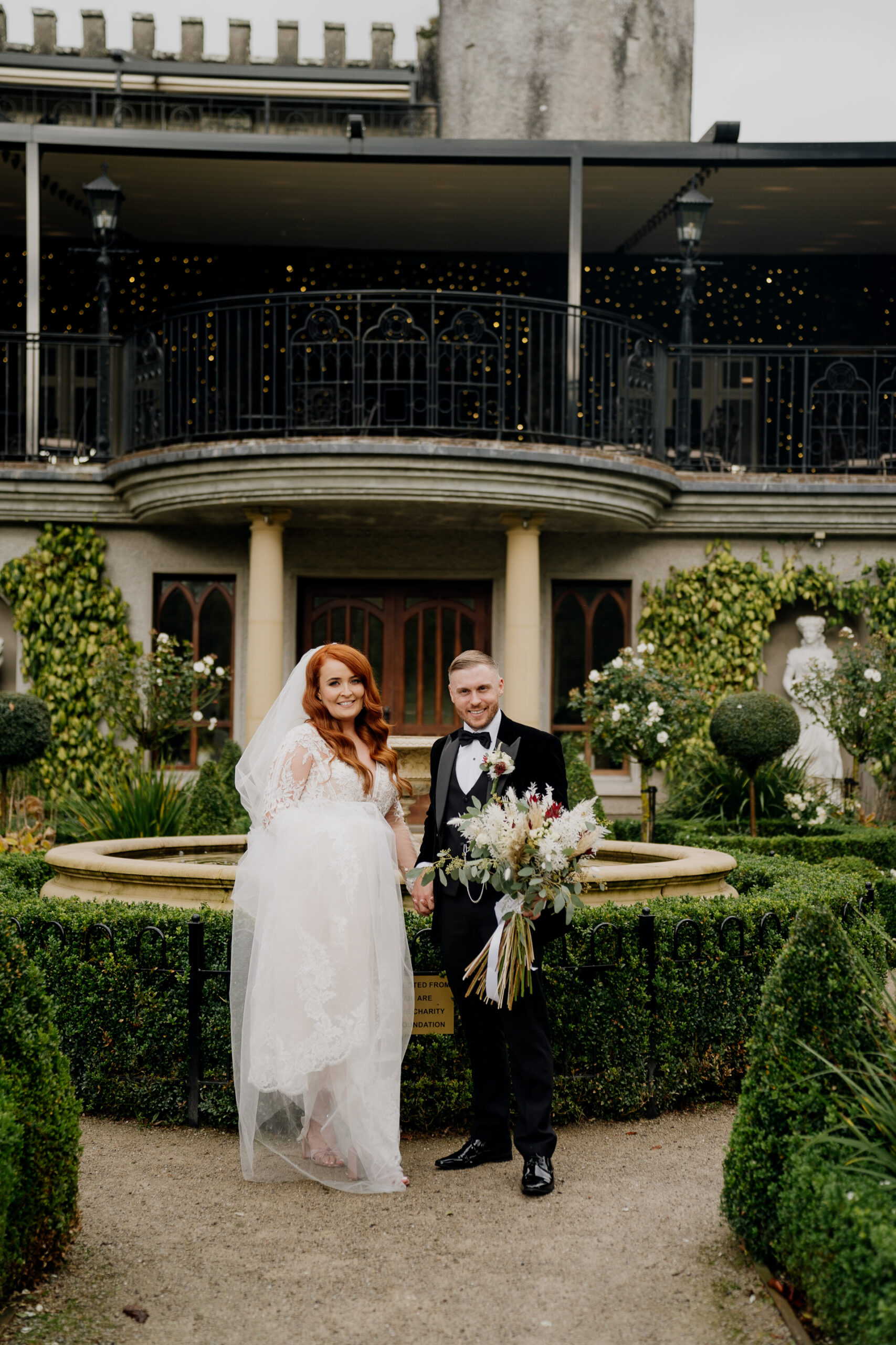 A man and woman posing for a picture in front of a building