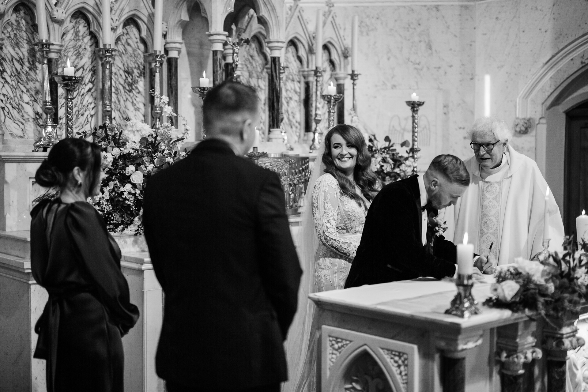 A group of people standing around a table with flowers and candles