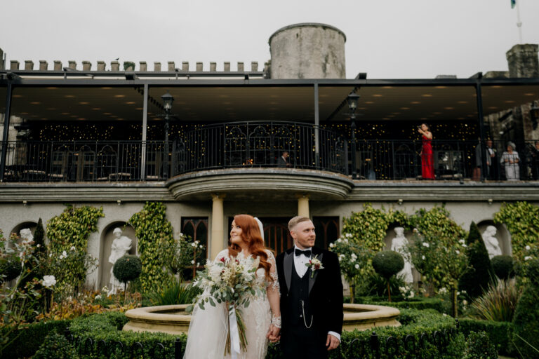 A man and woman posing for a picture in front of a building