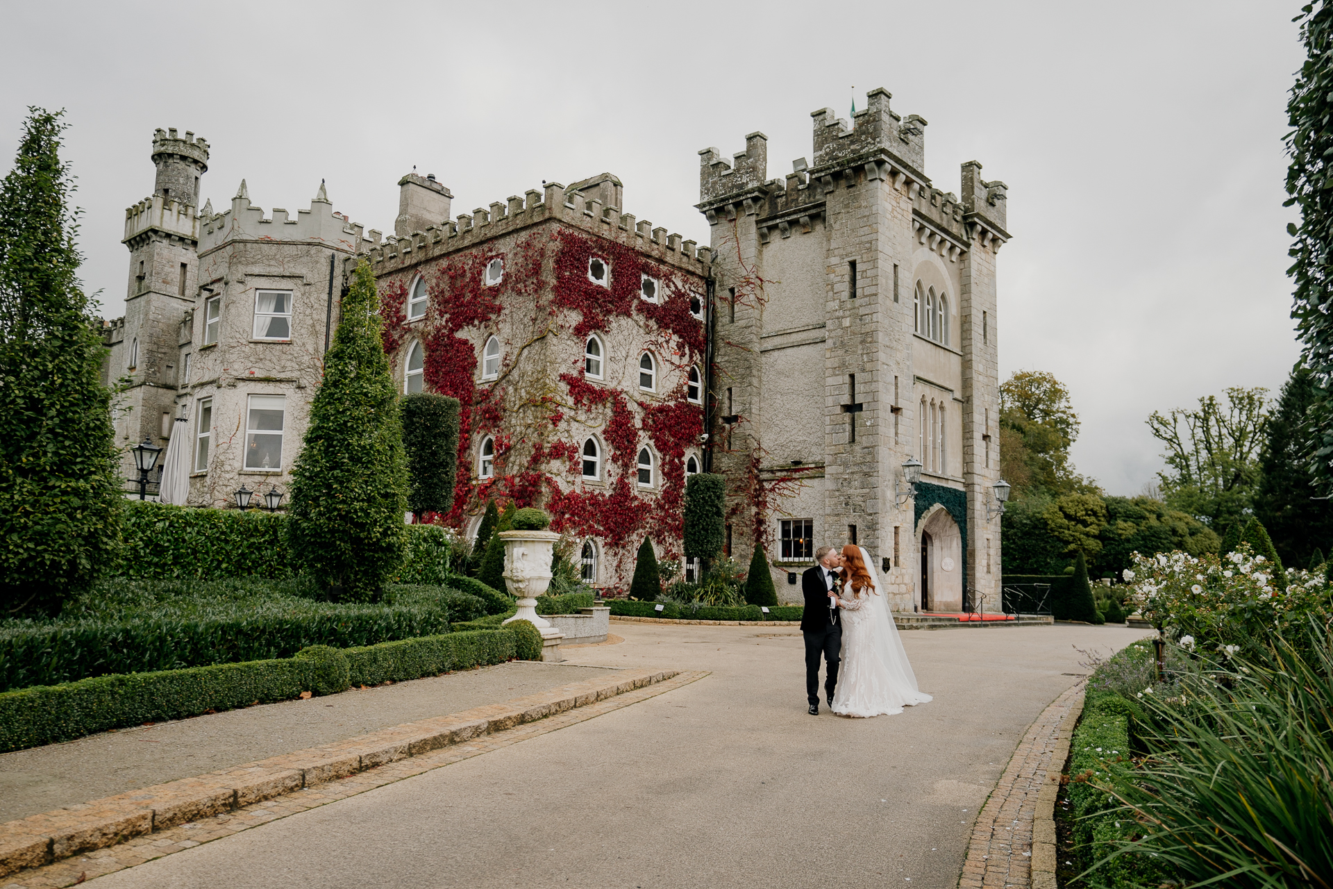 A bride and groom in front of a large castle