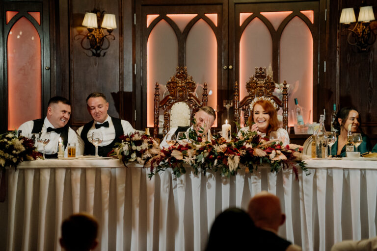 A group of people sitting at a table with flowers