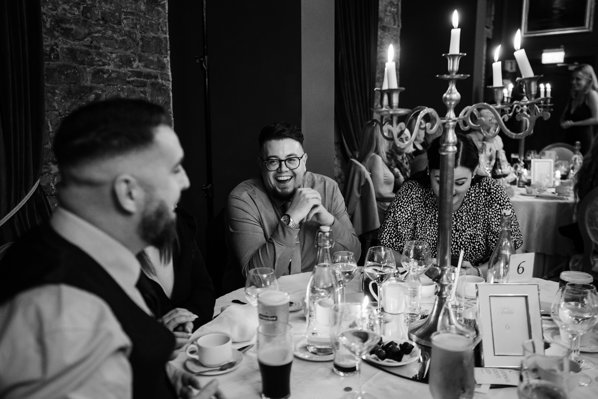 A group of men sitting at a table with food and drinks