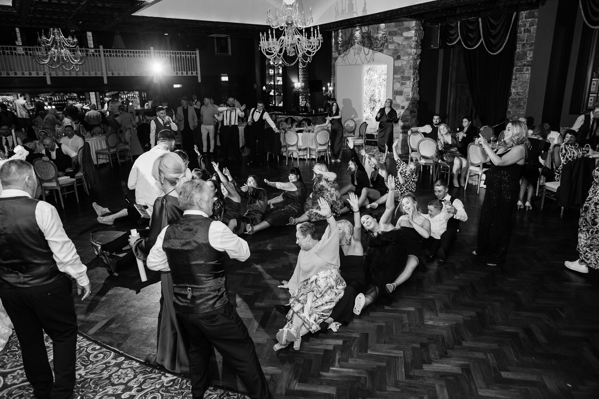 A group of people dancing in a room with a chandelier