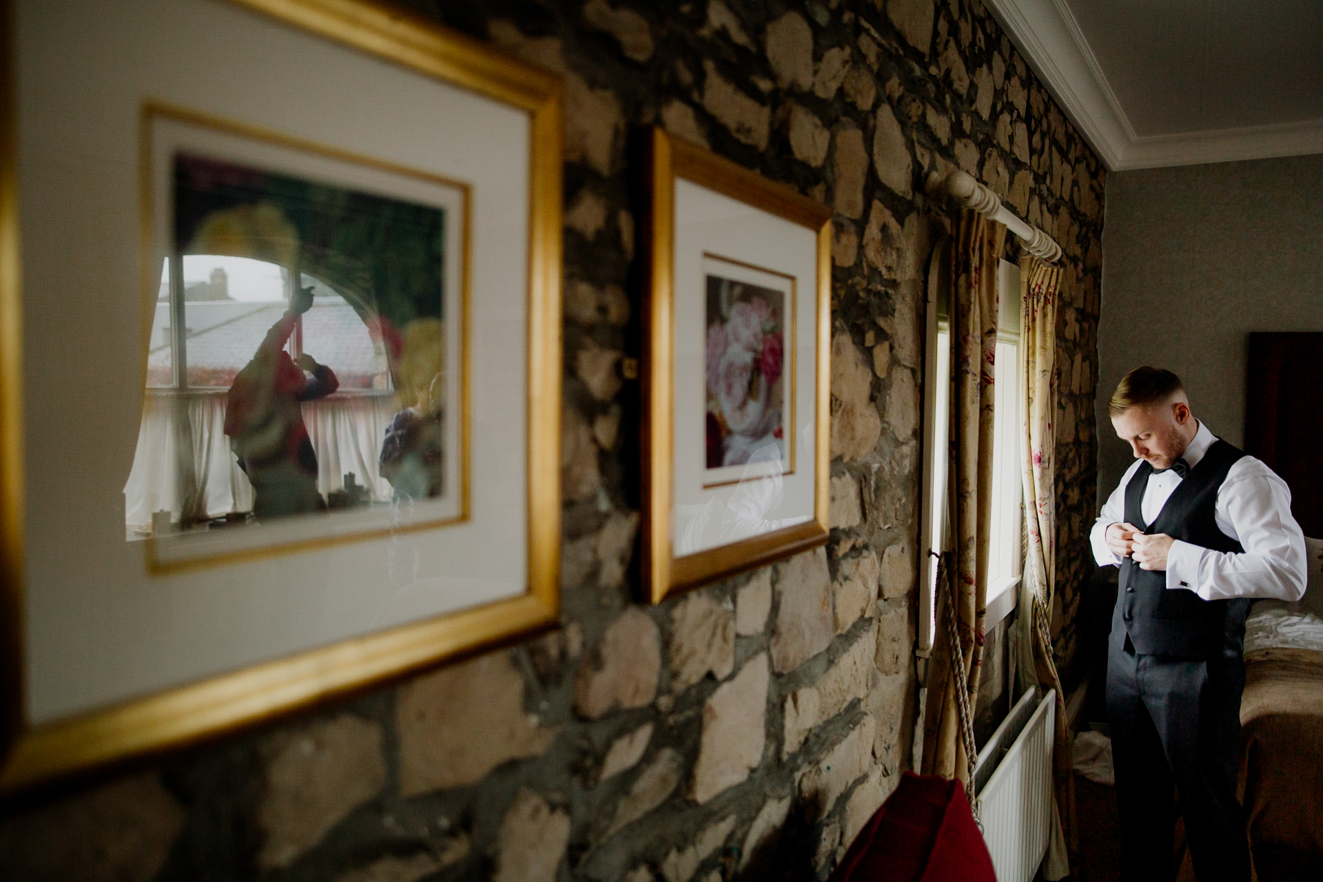 A man standing next to a wall with paintings on it