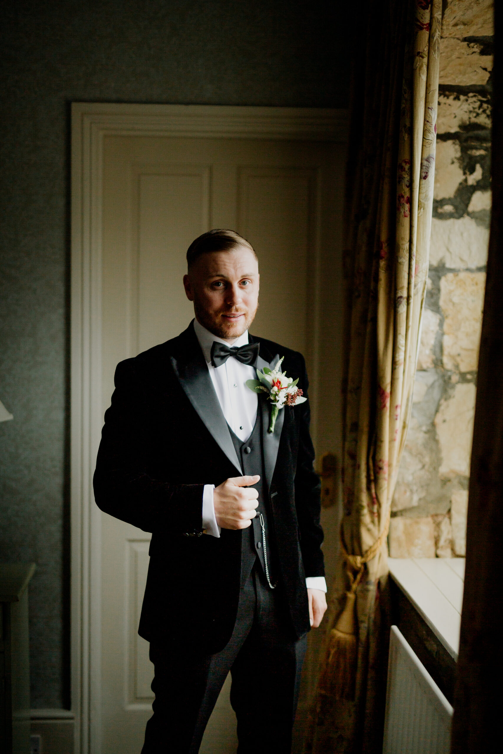 A man in a tuxedo holding a bouquet of flowers