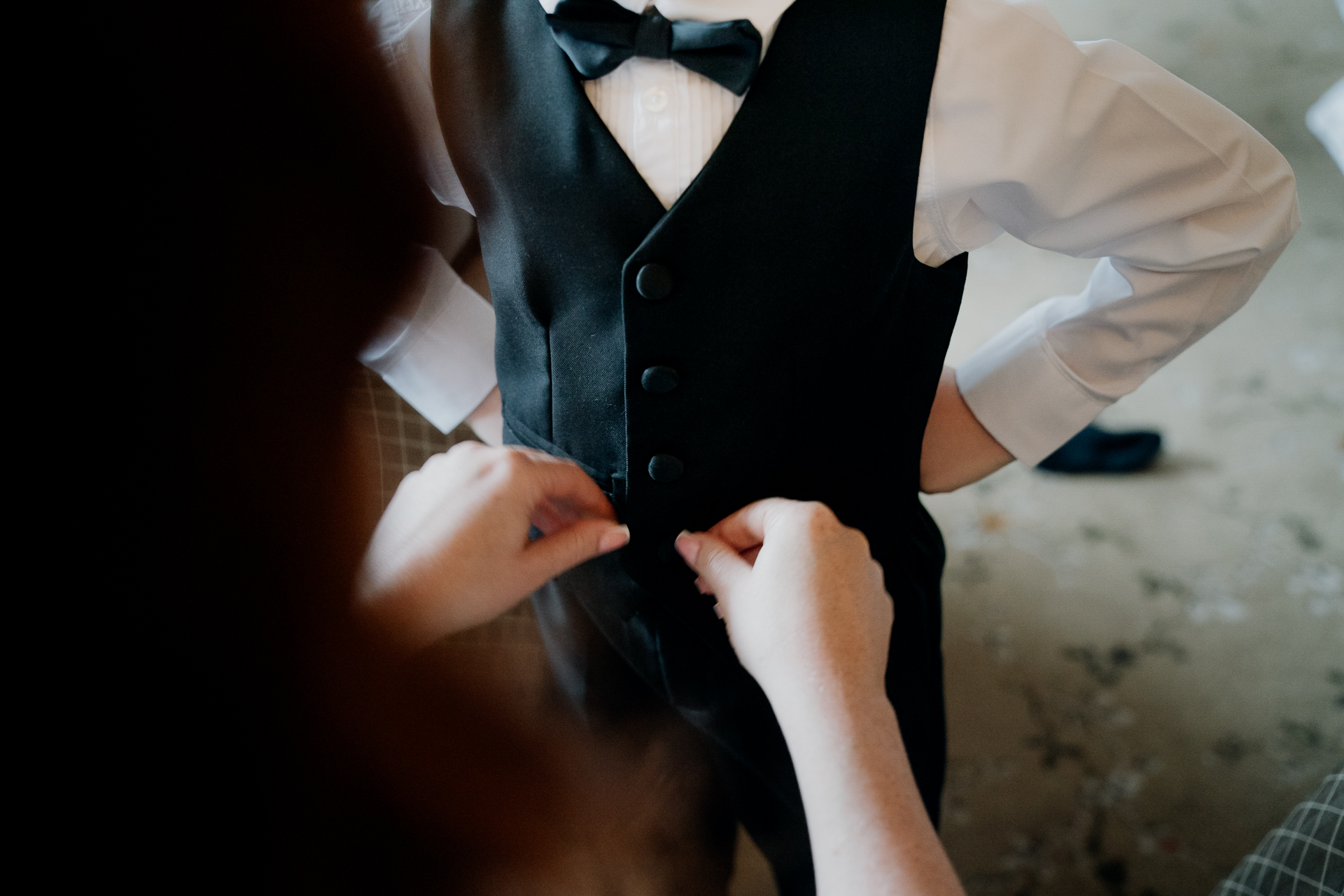 A man in a suit and bow tie holding a phone