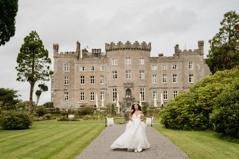 A person in a white dress in front of a large building