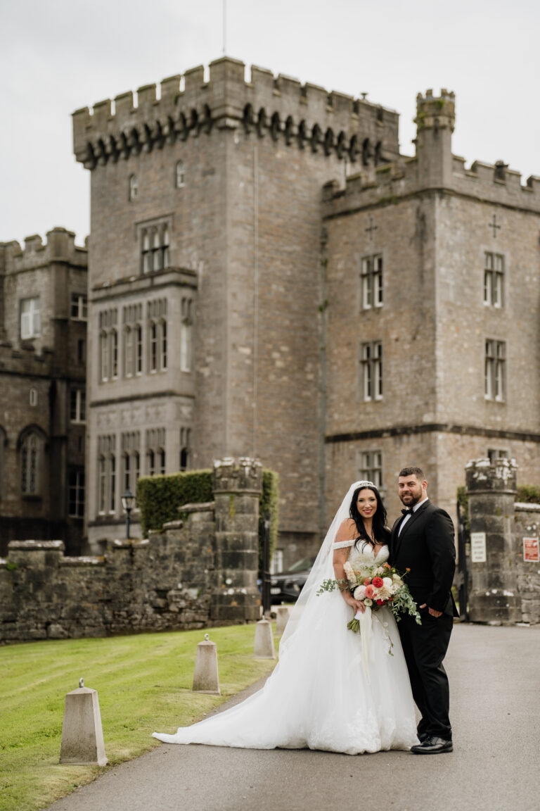 A bride and groom in front of a castle