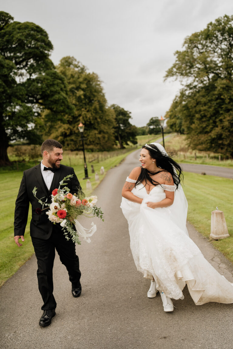 A man and woman walking down a road with flowers