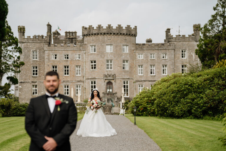 A man and woman in wedding attire in front of a large building