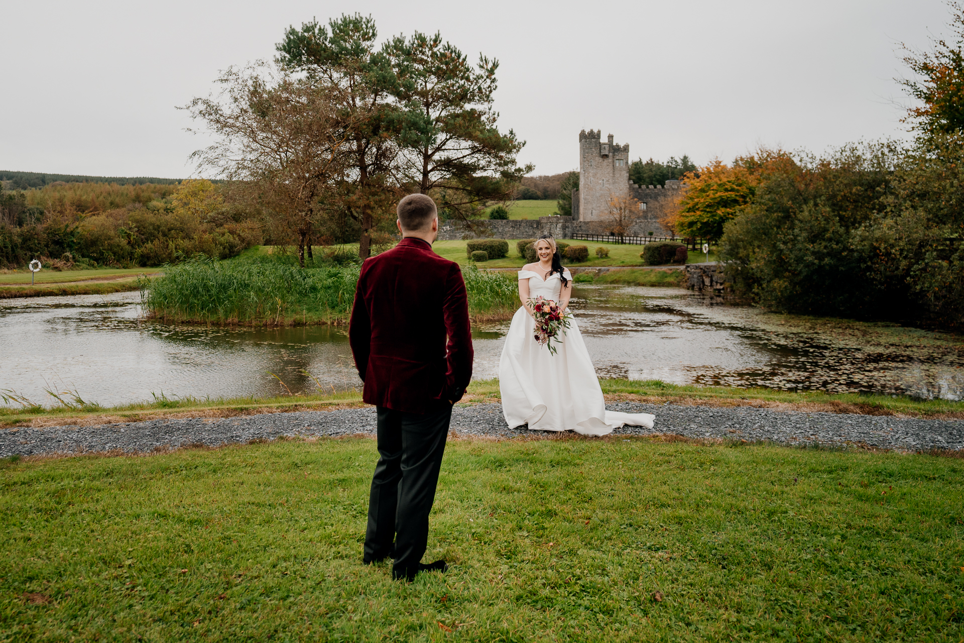 A man and woman in a wedding dress standing in a grassy field