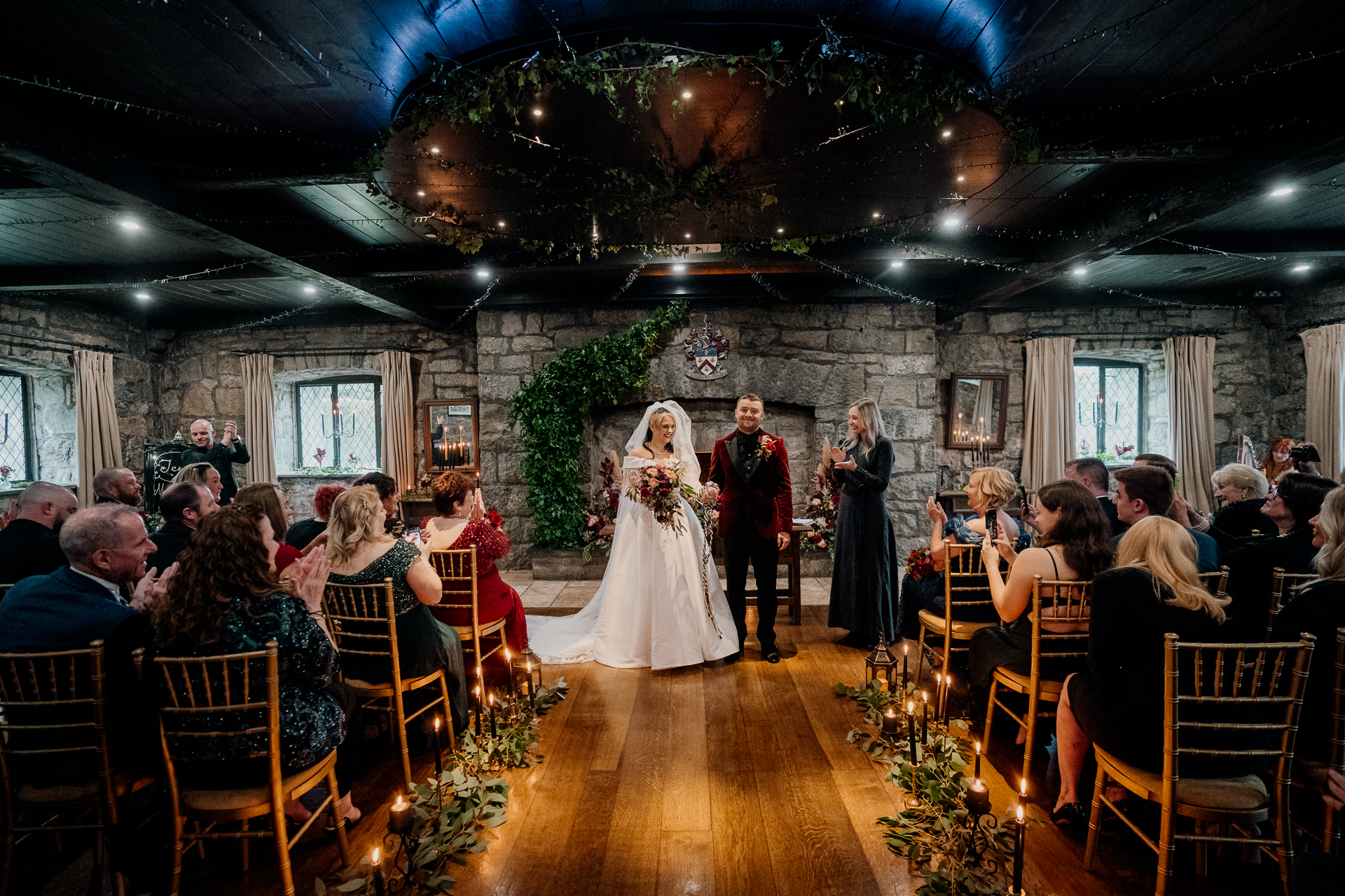 A man and woman walking down a hall with a couple of people in a wedding dress